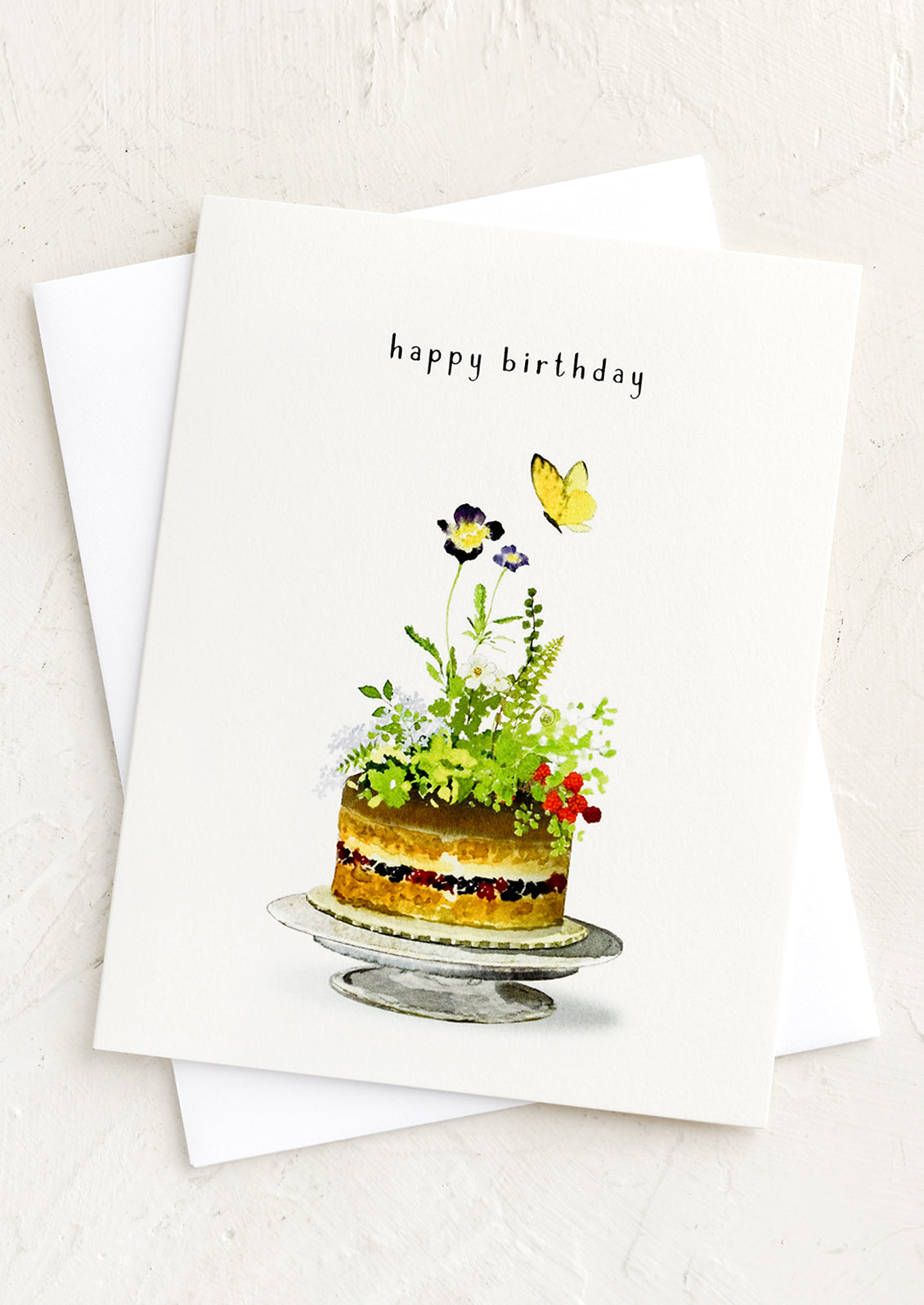 A greeting card with illustration of floral cake, text above reads "happy birthday".