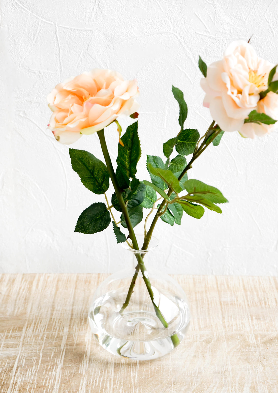 Realistic faux rose flowers in glass vase