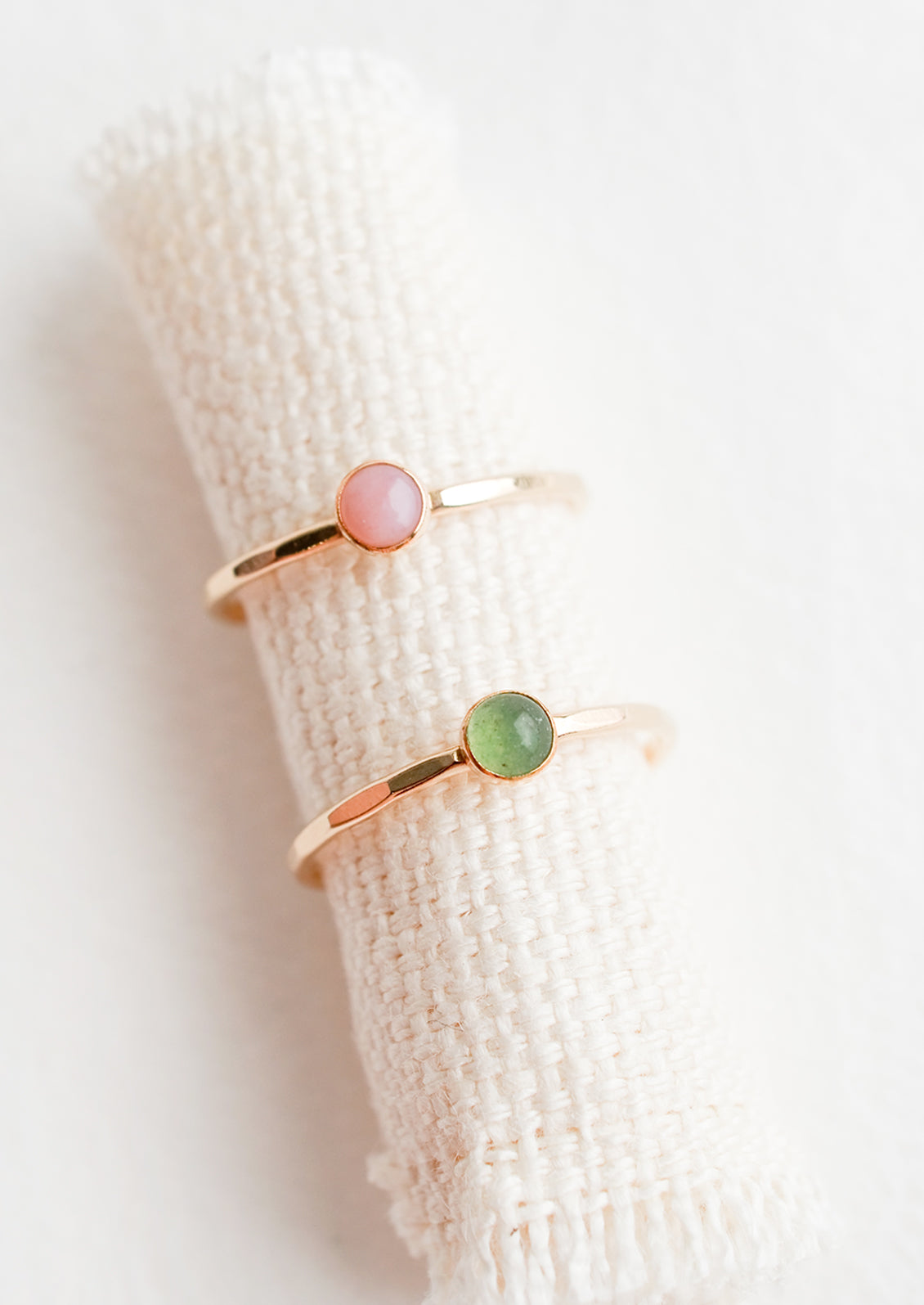 Thin gold rings with bezel set gemstones.
