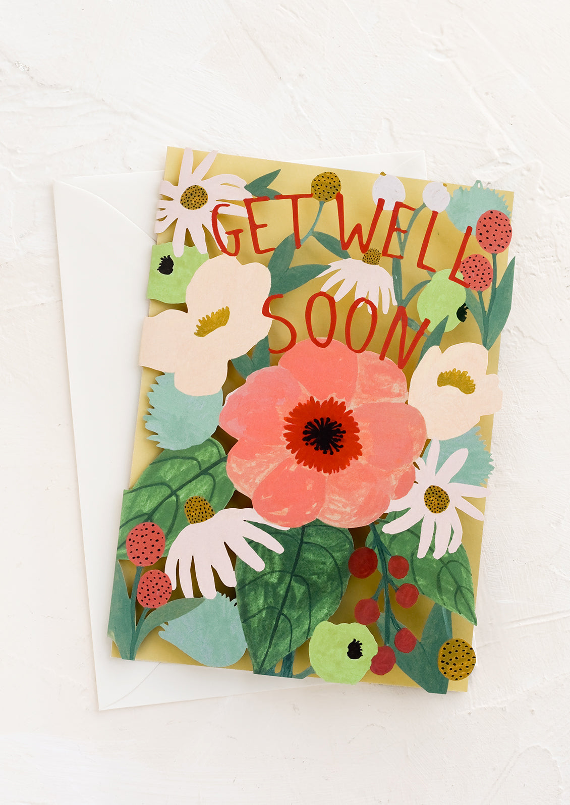 A lasercut floral greeting card reading 'get well soon'.