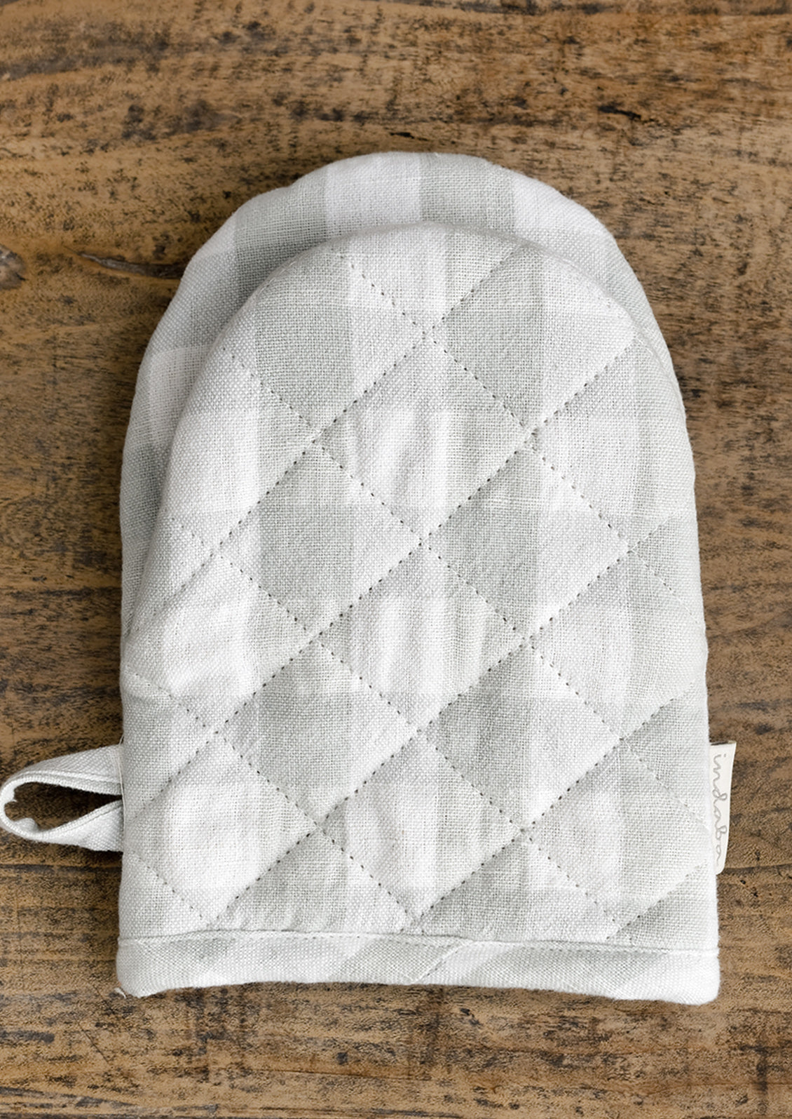 A gingham oven mitt in pale blue colorway.