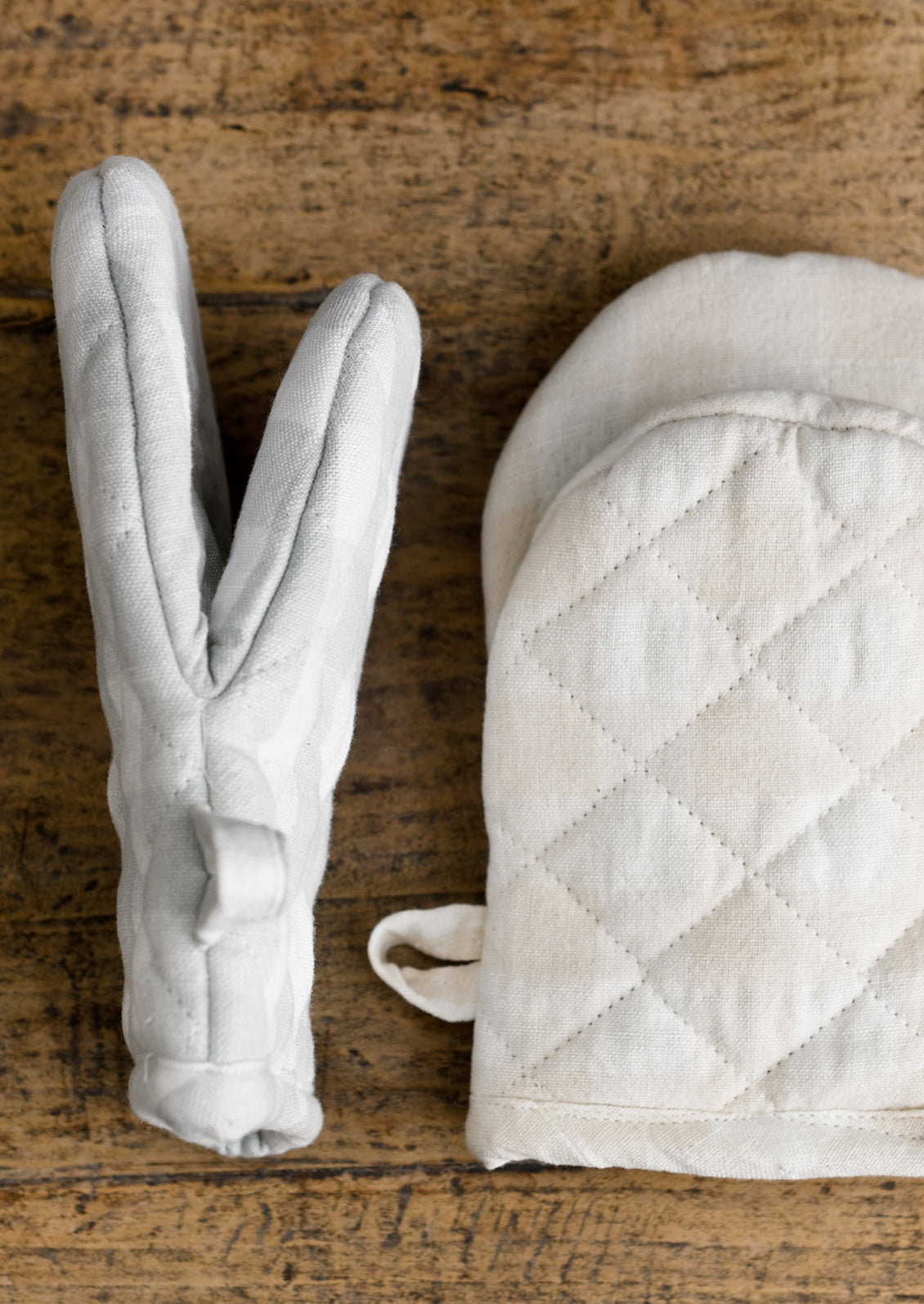 Gingham oven mitts in two pastel colors.