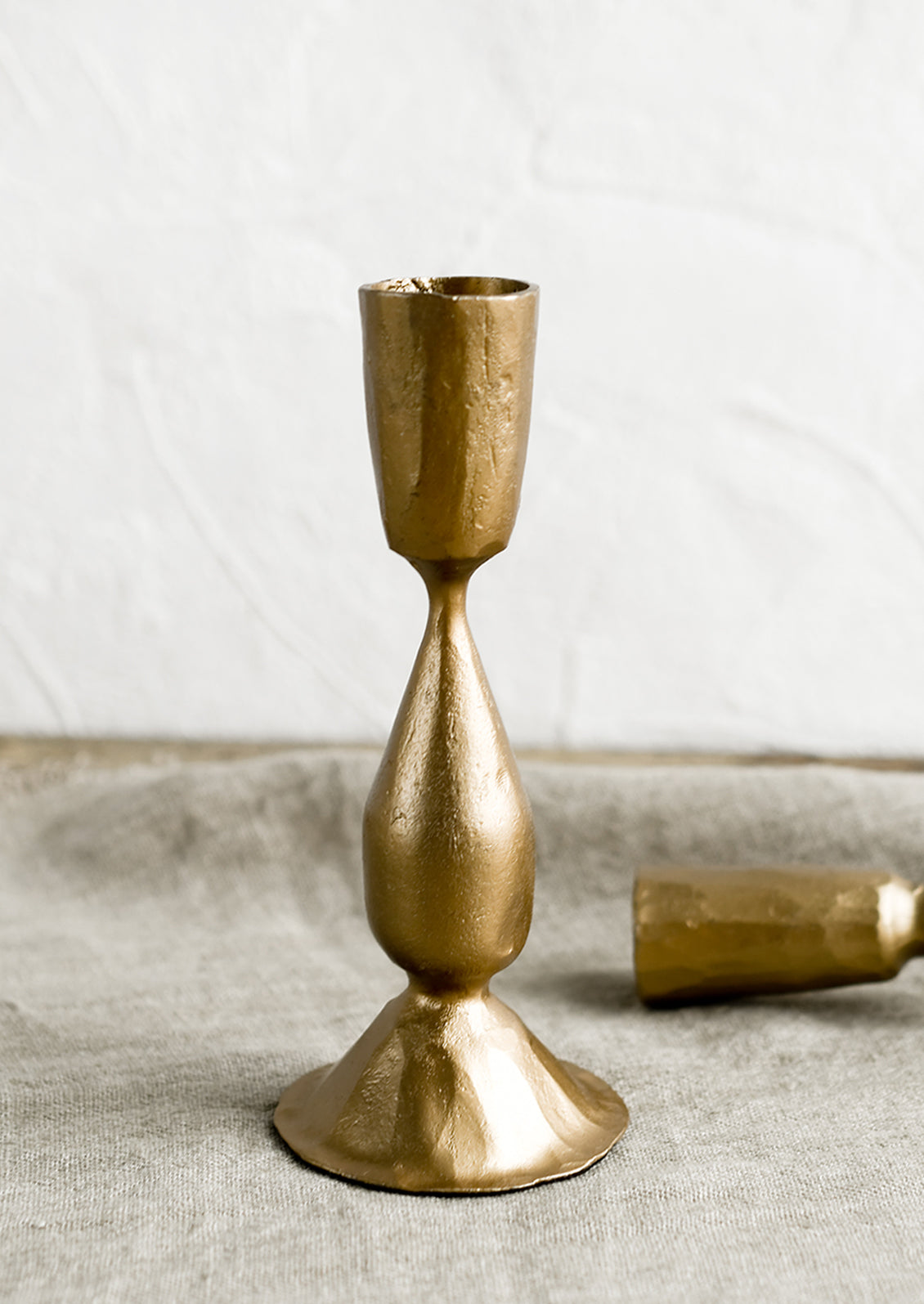 A candlestick holder in gold finish cast iron.