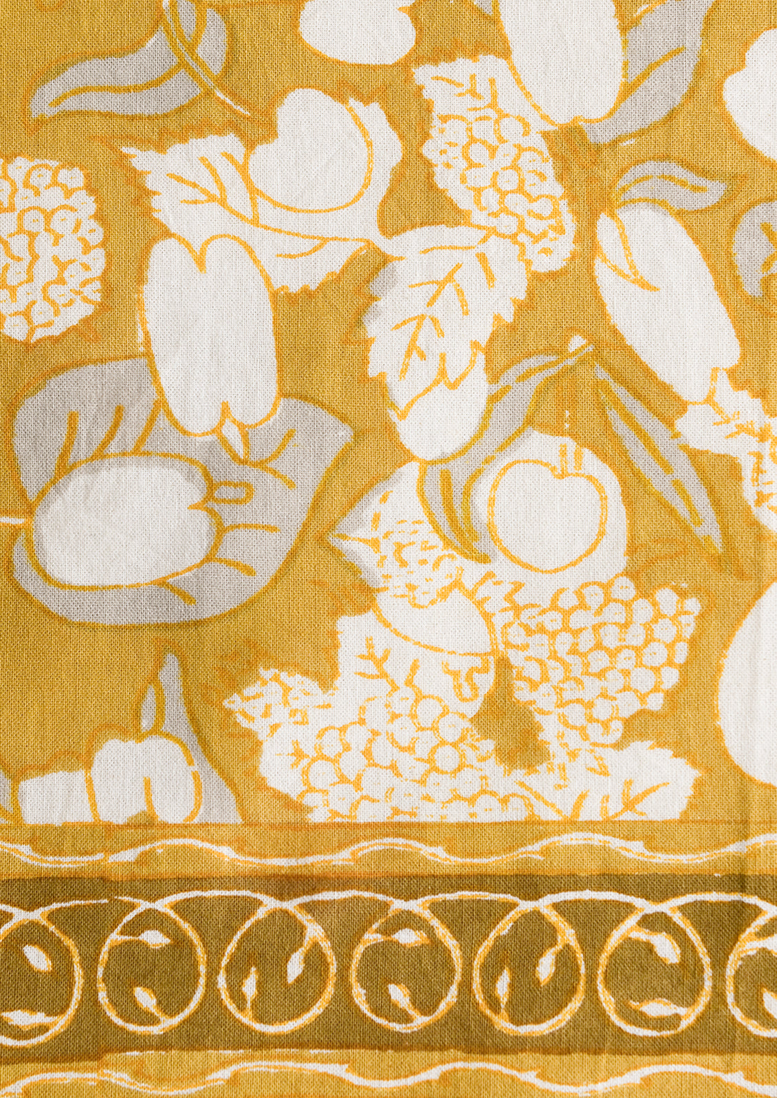 A pair of mustard/gold napkins with fruit print.