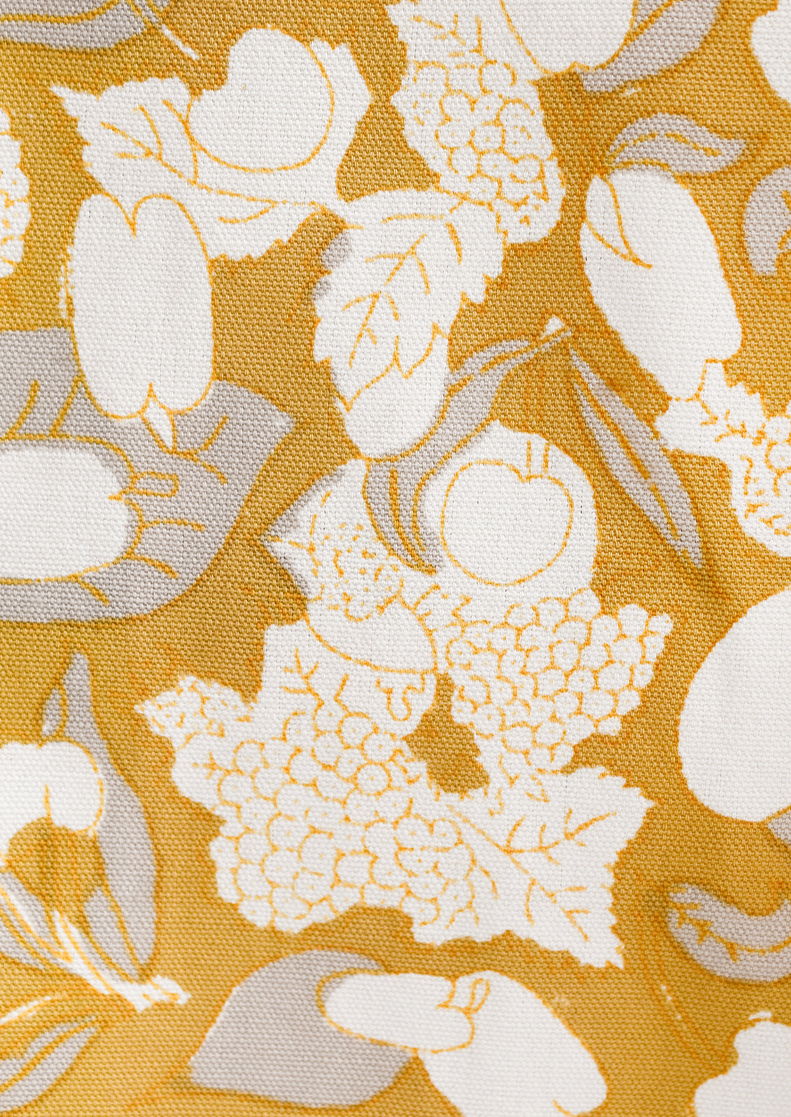 A gold, grey and white fruit print tea towel.