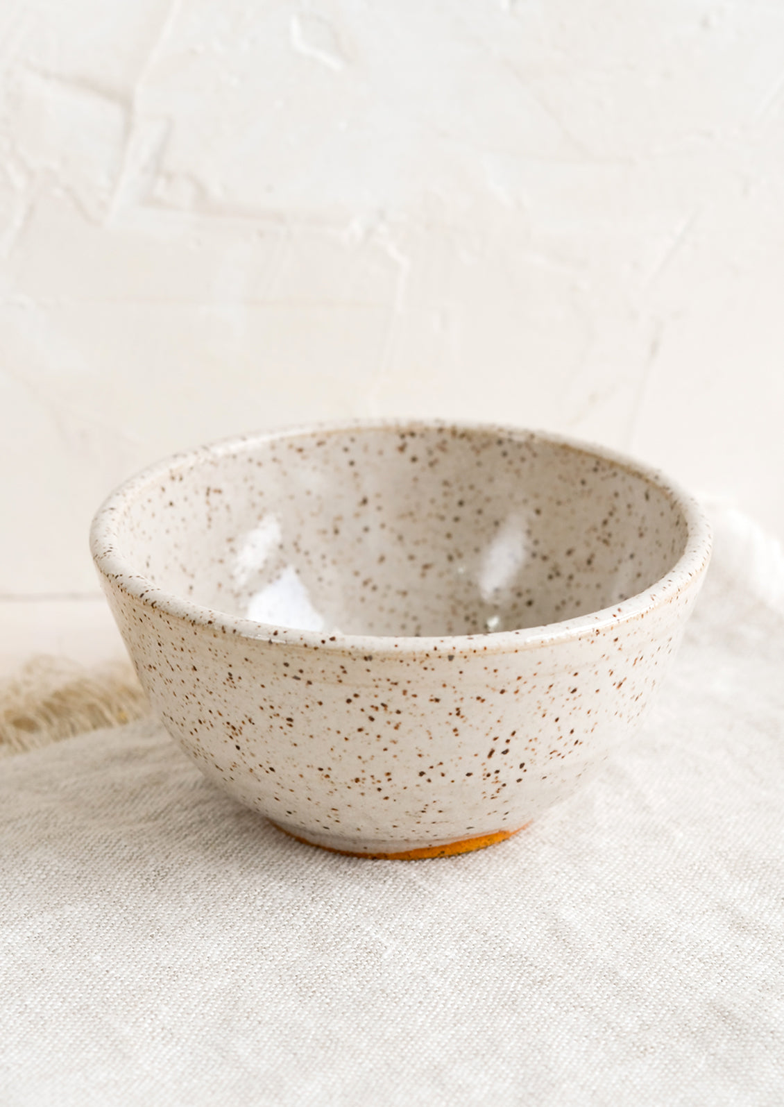 A small ceramic bowl in speckled white.