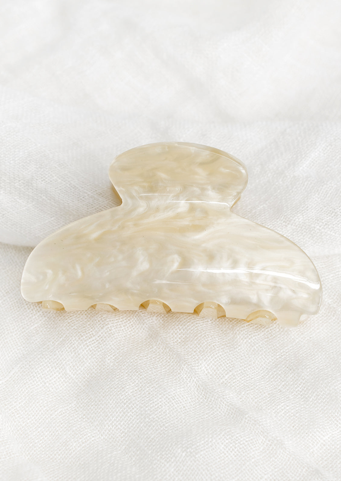 A plastic hair claw in pearlized ivory.