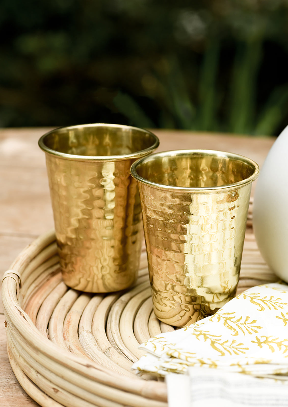 Two hammered brass tumblers on a tray.