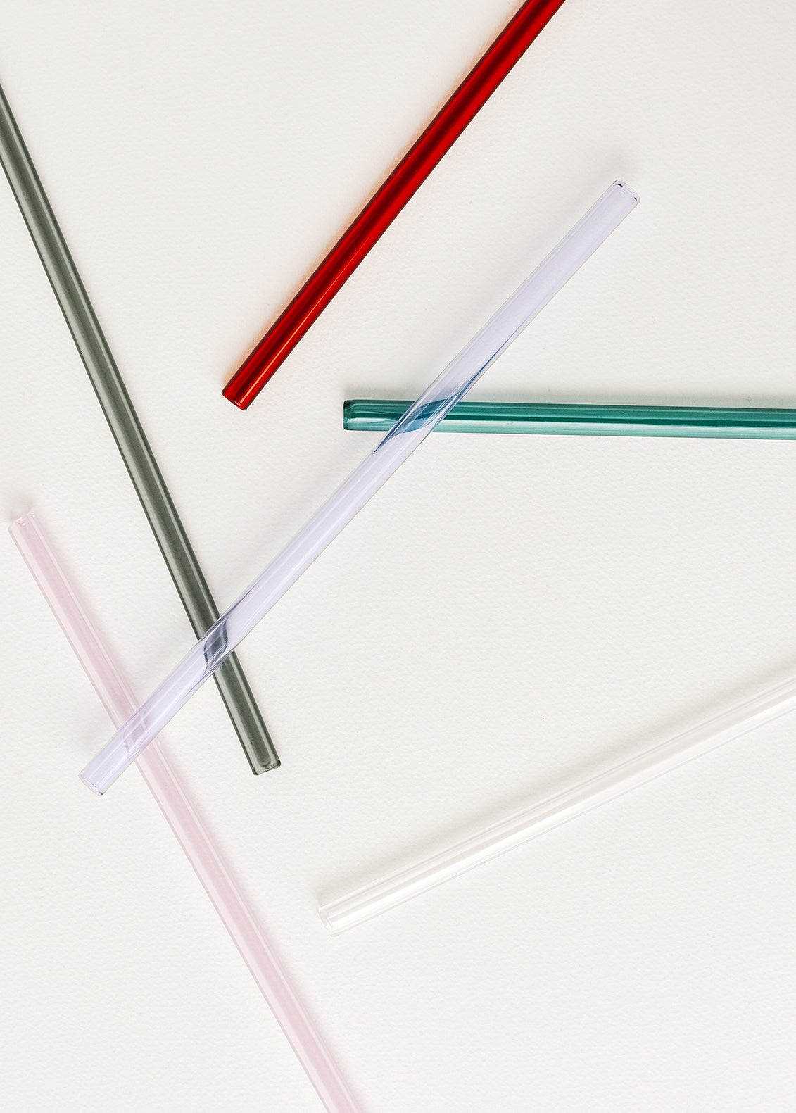 Scattered glass straws in assorted colors.