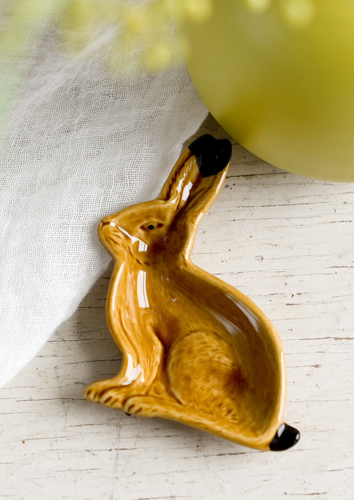 A rabbit shaped ceramic trinket dish in brown.