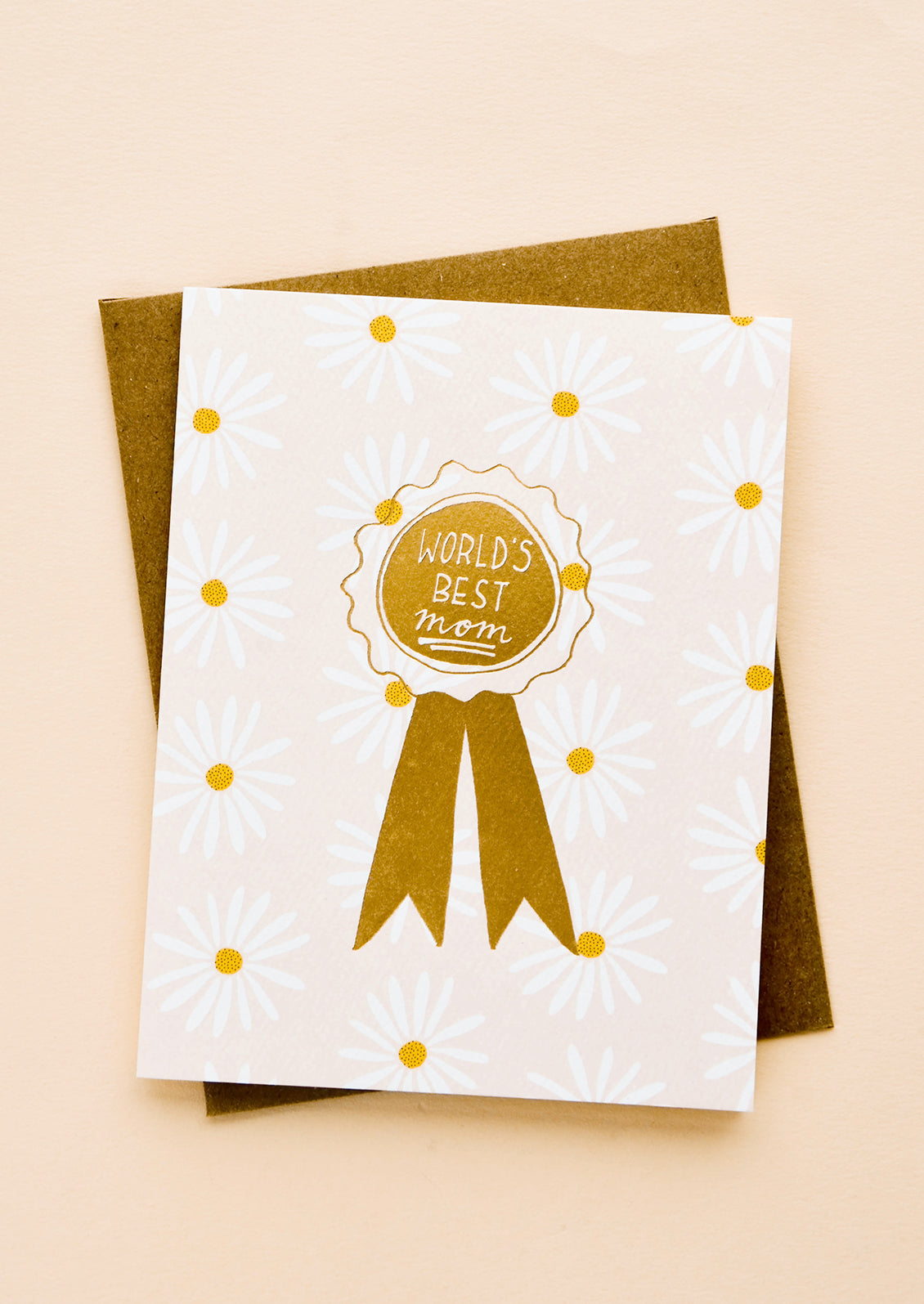 Greeting card with allover daisy pattern and gold ribbon reading "World's Best Mom" 