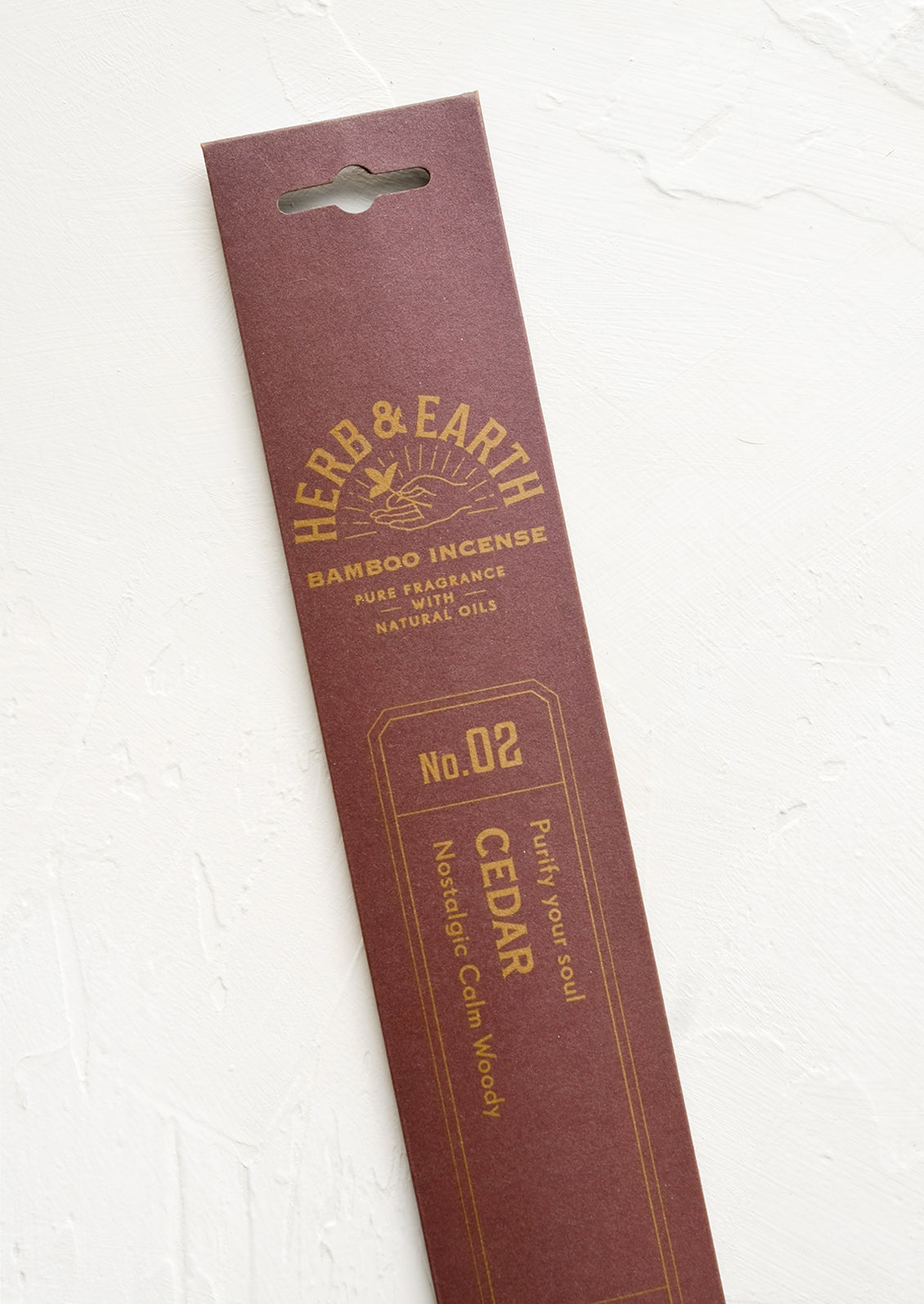 A brown packaging sleeve containing cedar scented incense.