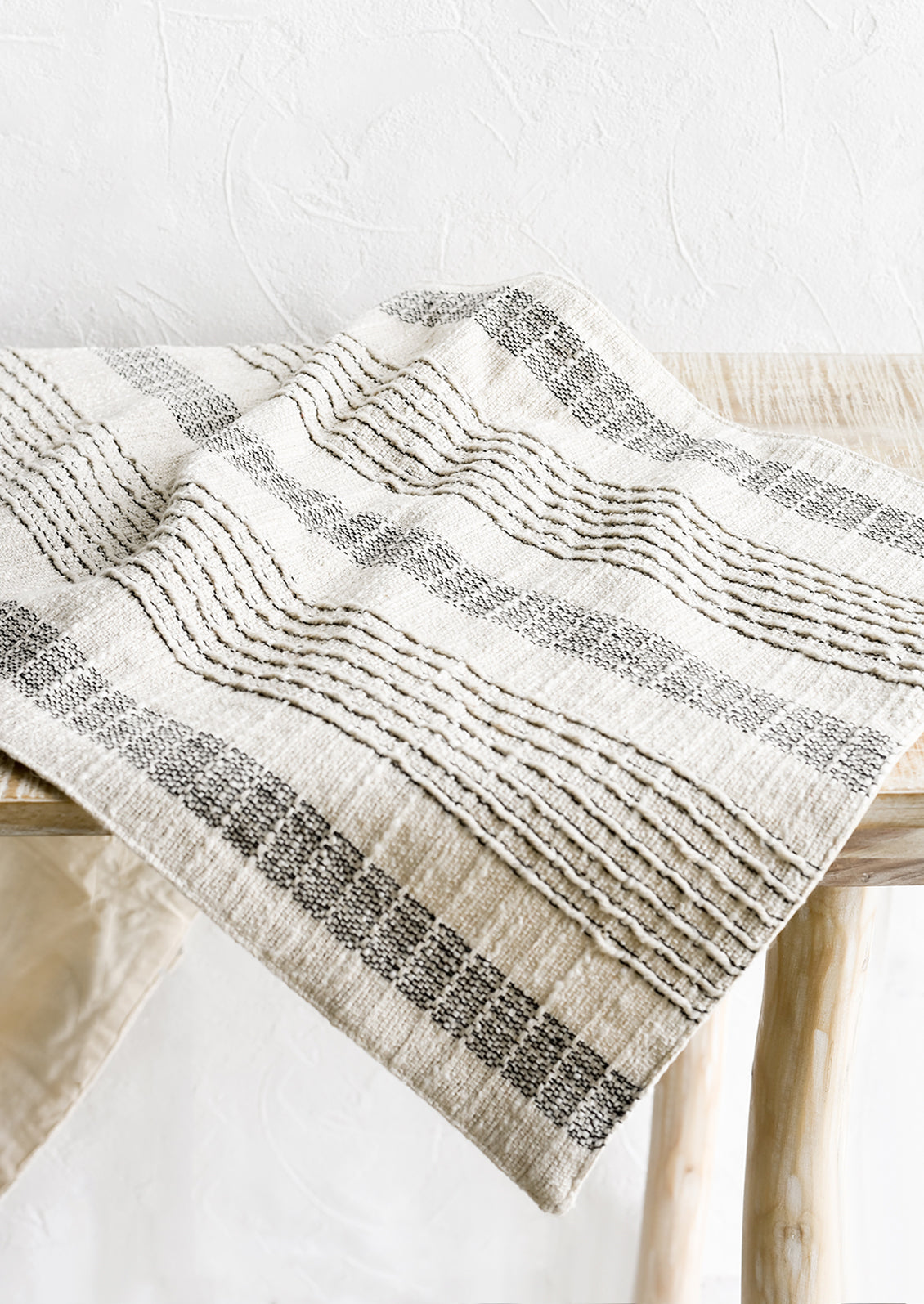 A cream and black striped table runner on a table.