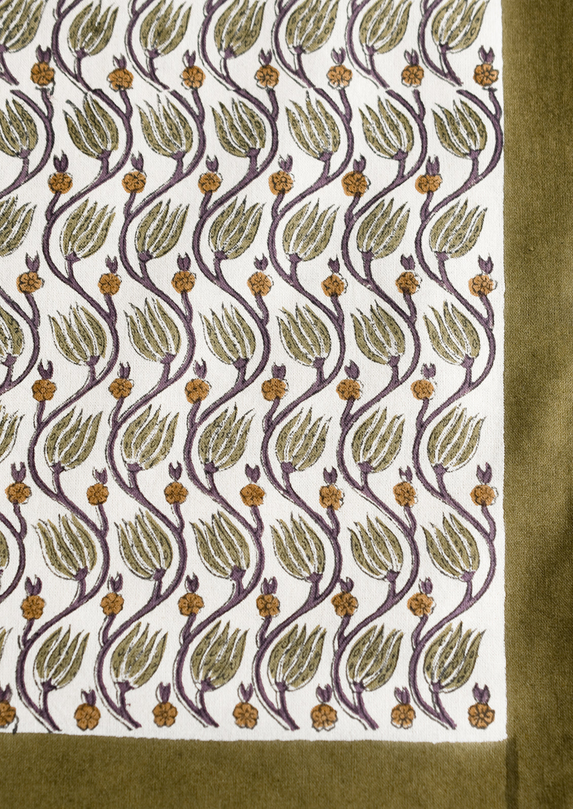 A botanical print tablecloth with olive green trim.