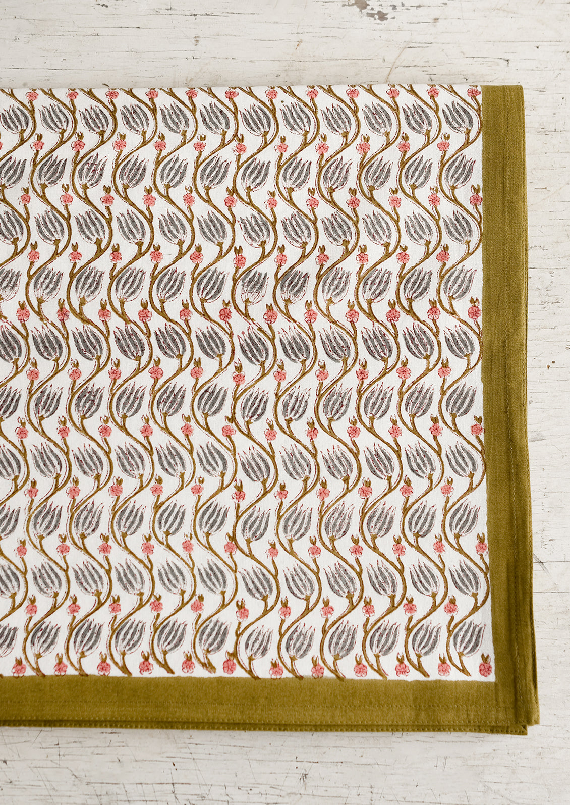 A botanical print tablecloth with khaki green trim.