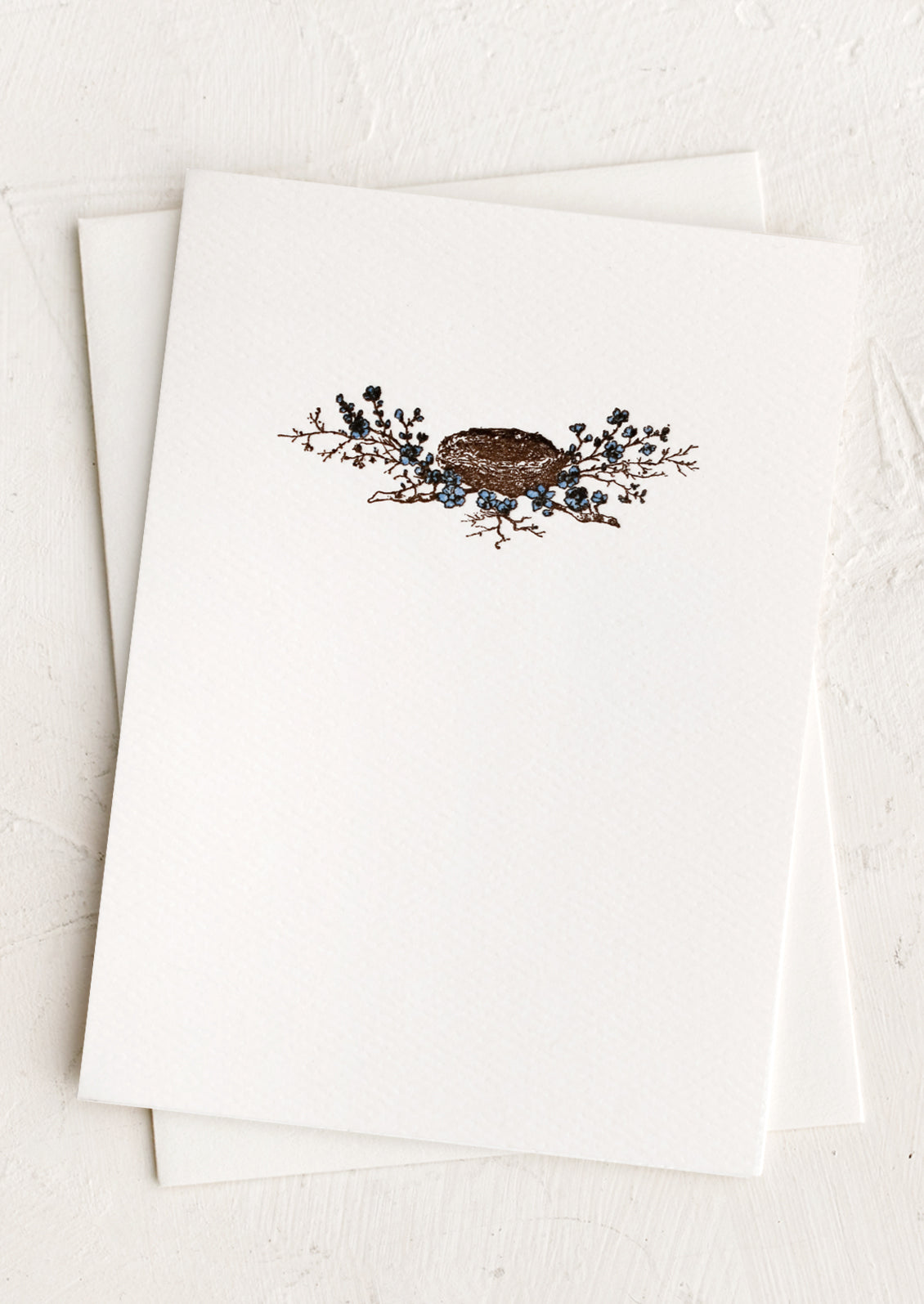 A plain white card with small bird's nest design at front.