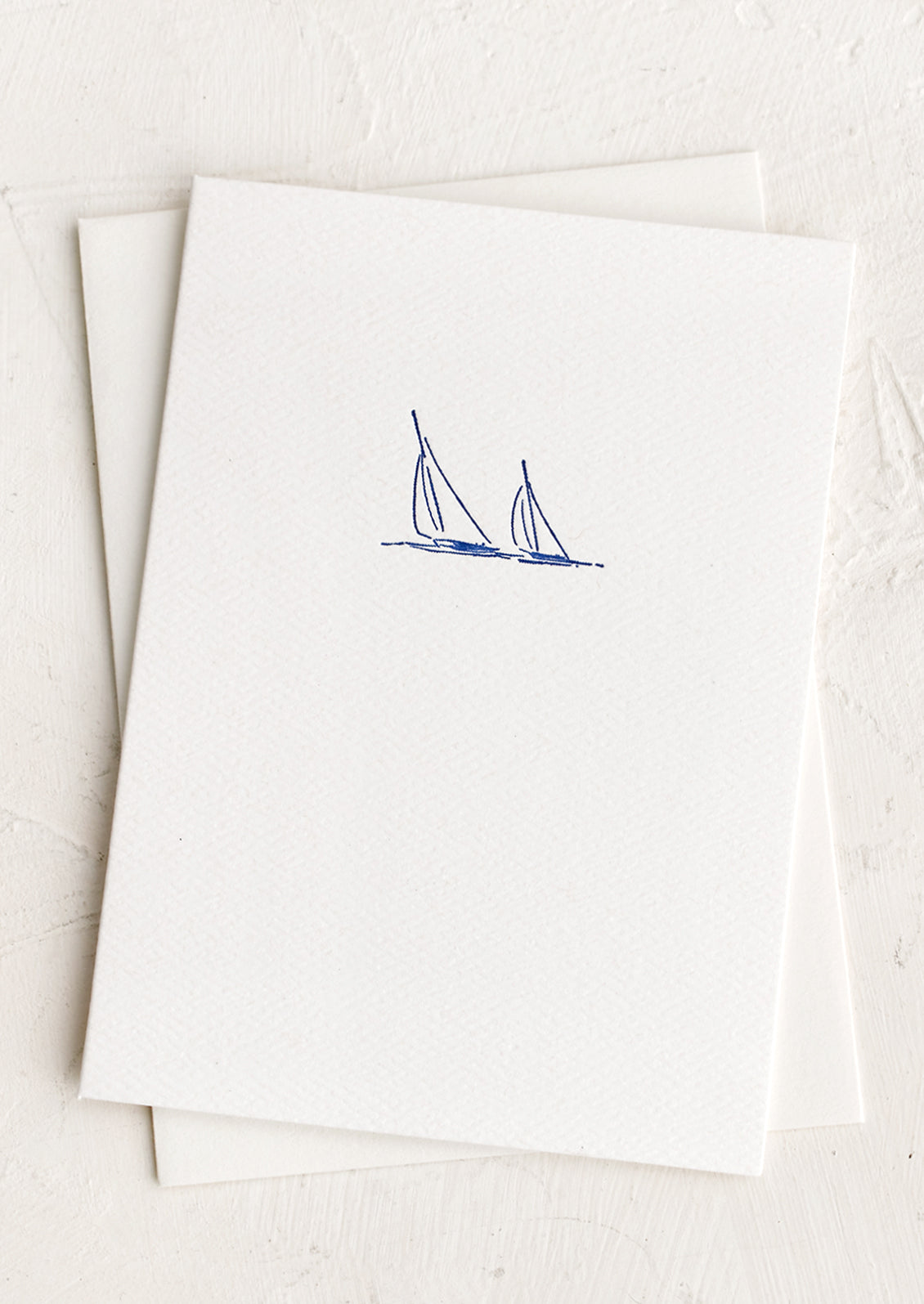 A plain white card with small sailboats icon at front.