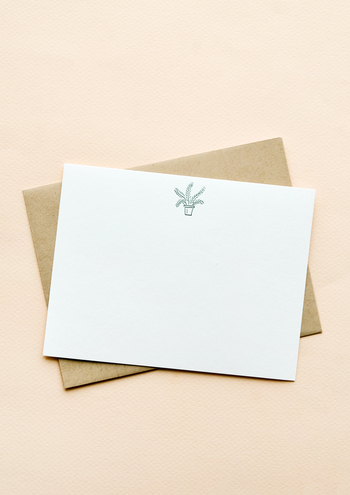A kraft envelope with white notecard and small icon of a potted plant printed at top.