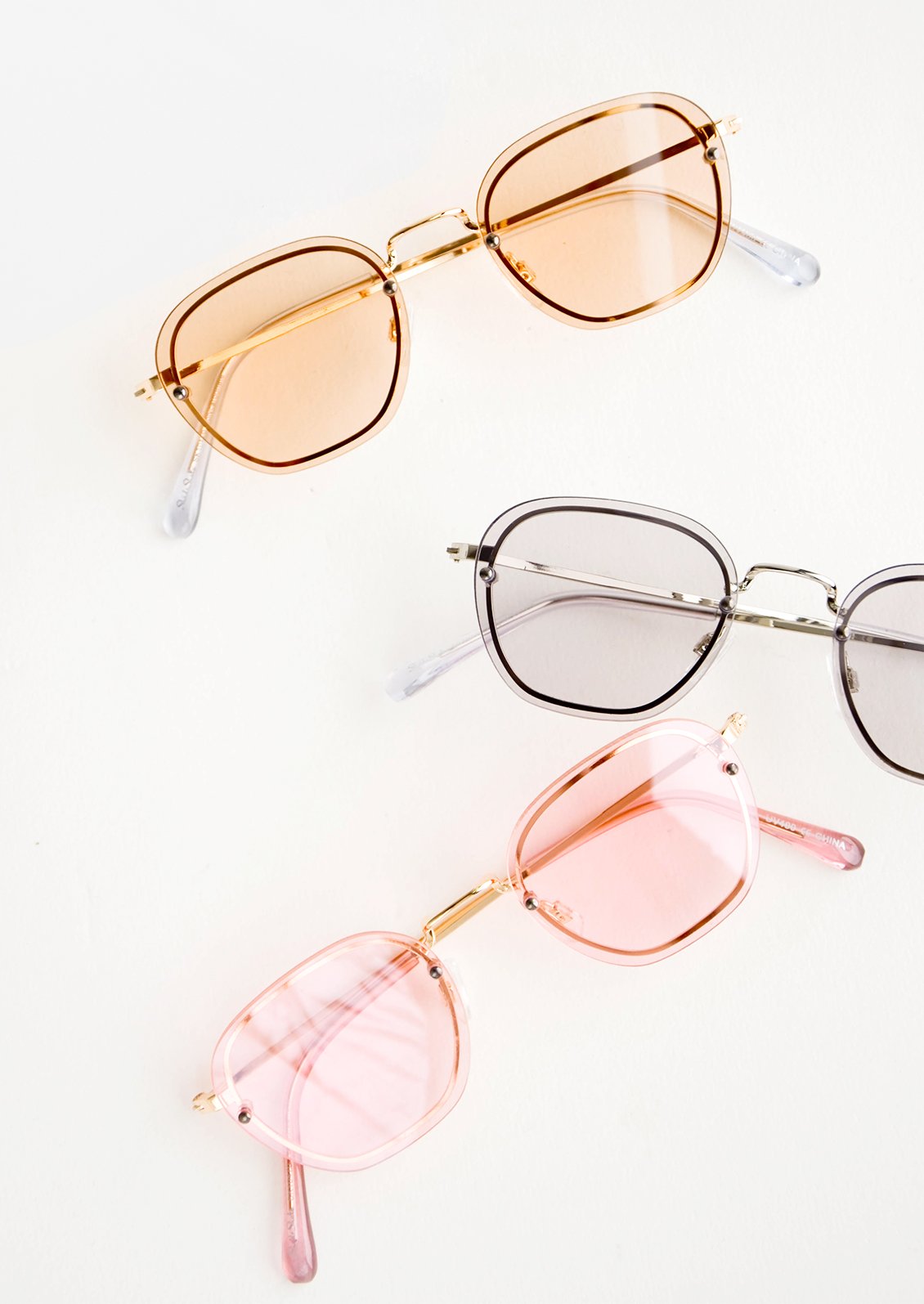 Sunglasses with light, color tinted plastic lenses and a metal frame behind the lens