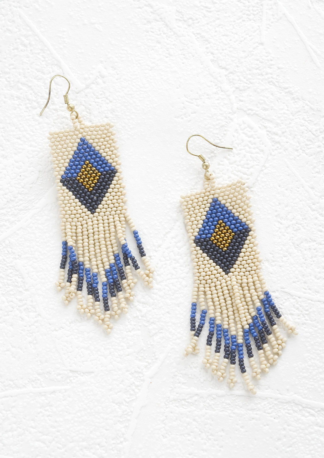 Ivory beaded fringe earrings with blue, gold and navy diamond design.