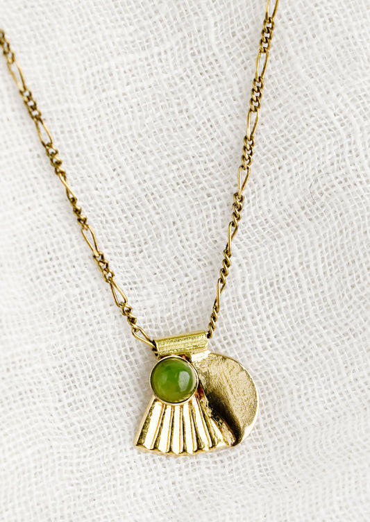 A neckace with art-deco style charm and jade bezel detail.