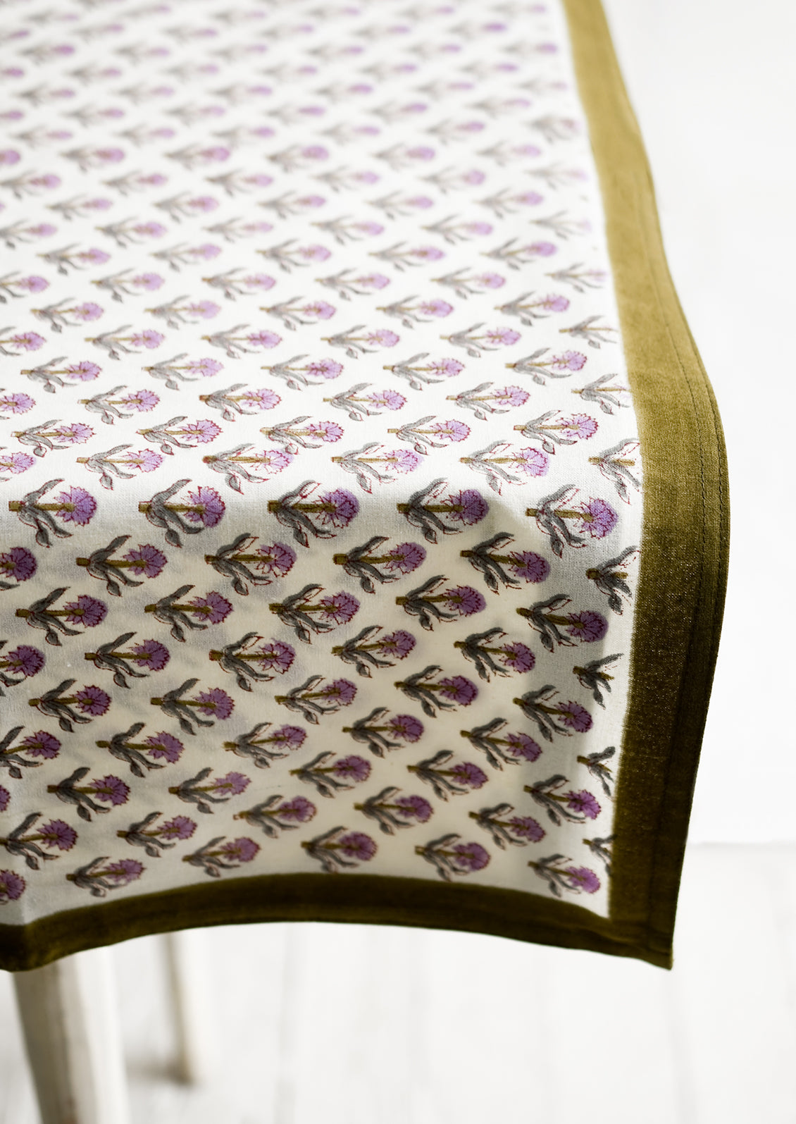 A purple and olive green floral print tablecloth.