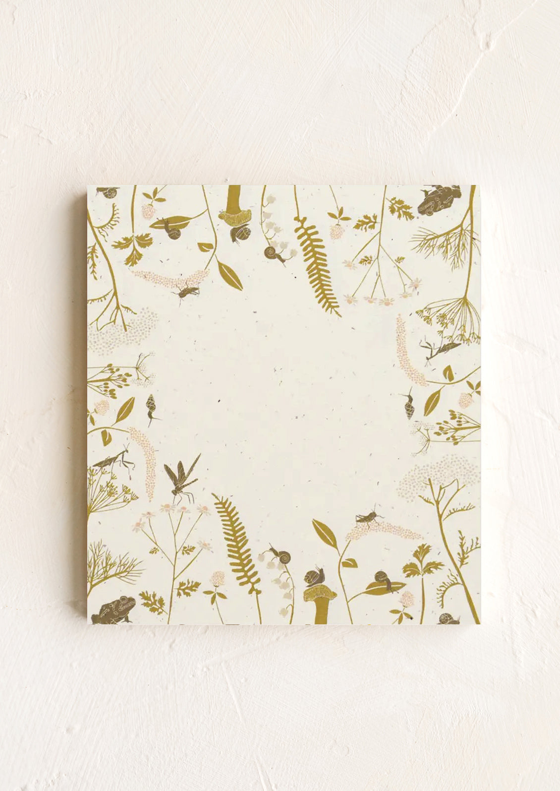 A small square notepad with bug print border.