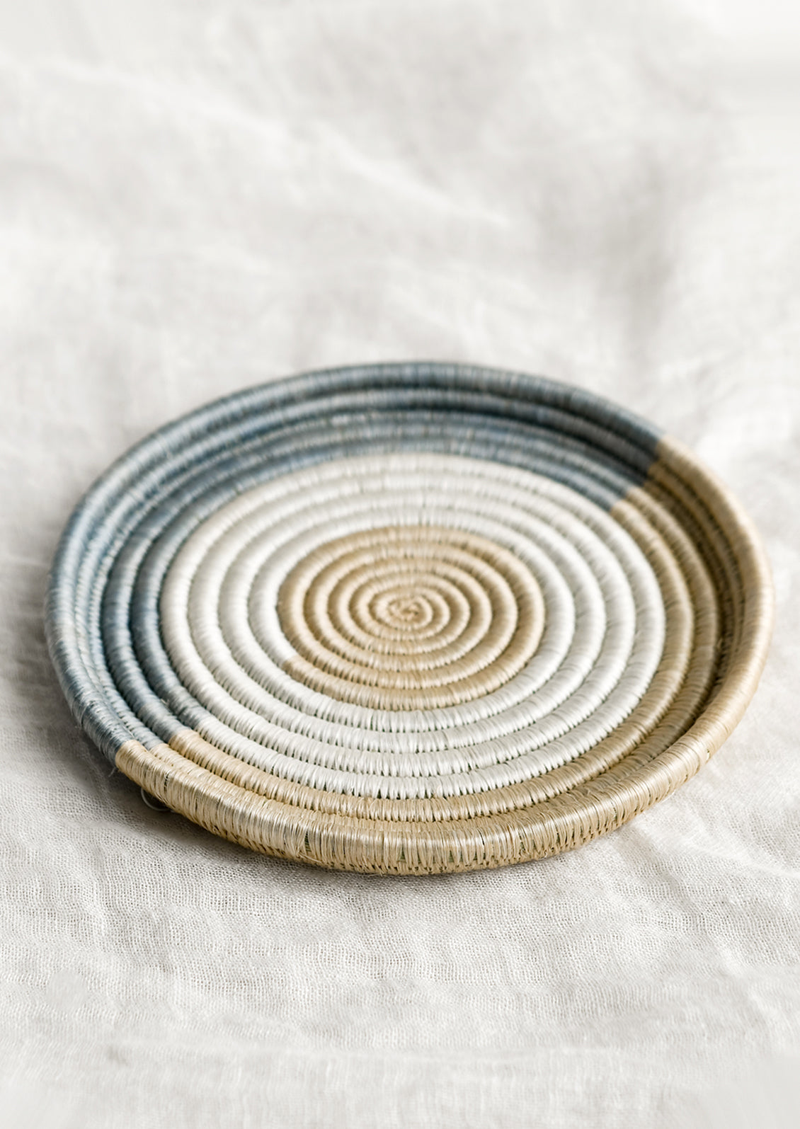 A round, shallow sweetgrass tray with lipped edge.