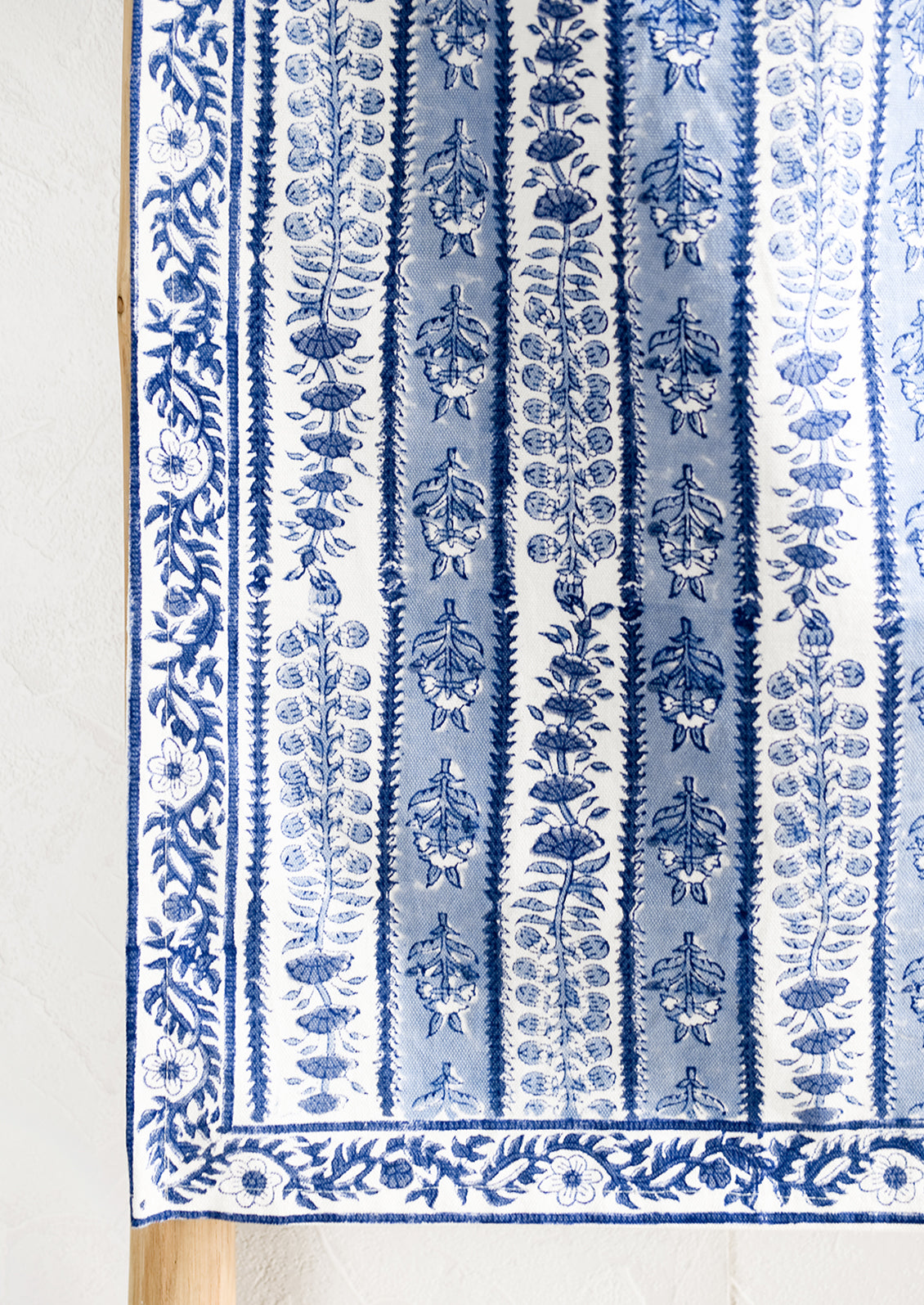 A stripe floral print table runner in blue and white.