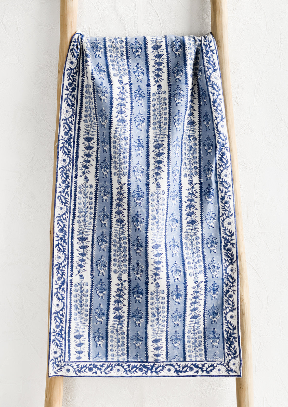 A stripe floral print table runner in blue and white.