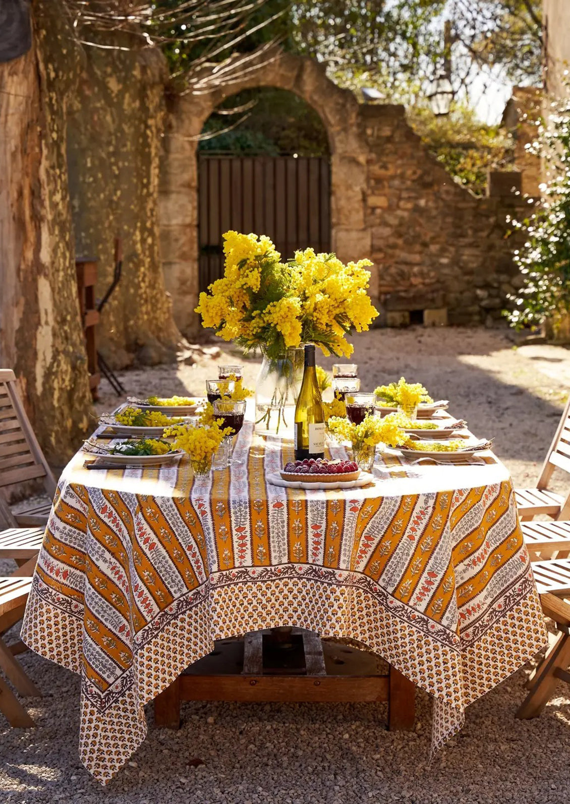 A stripe floral print tablecloth in marigold, purple and blue.