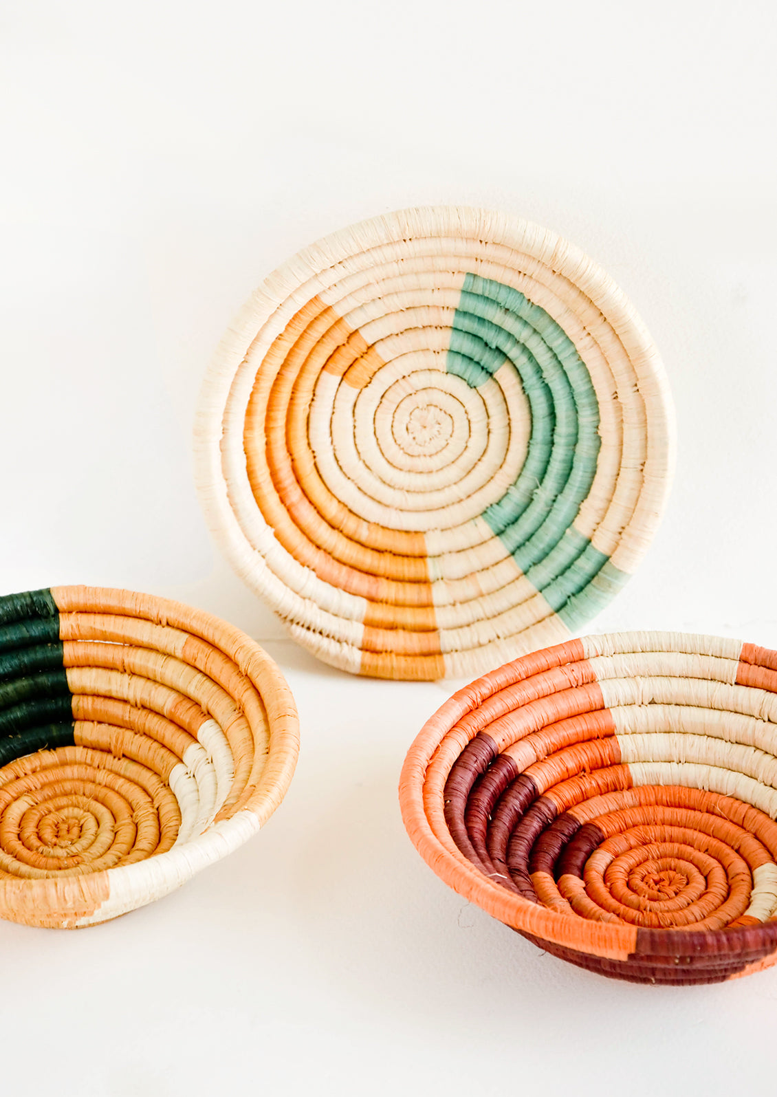 Assortment of three woven raffia bowls in a mix of color combos