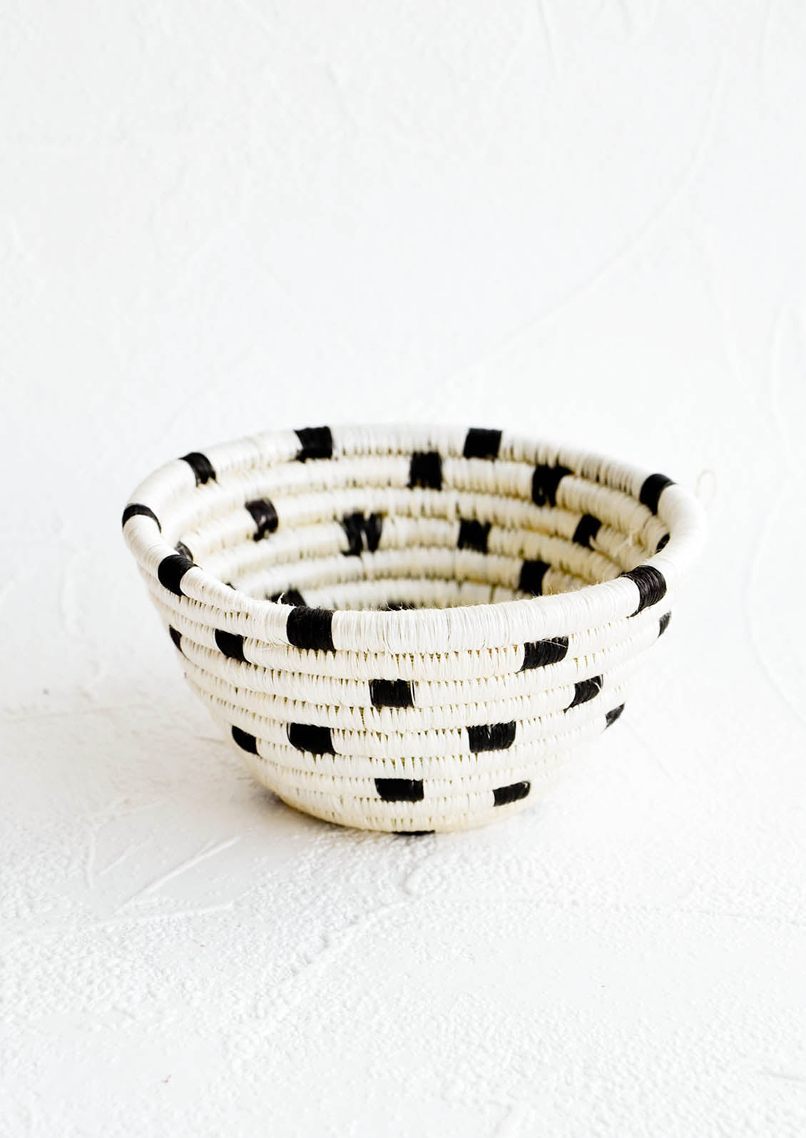 Small woven catchall bowl made from sweetgrass in a black and white dash print design.