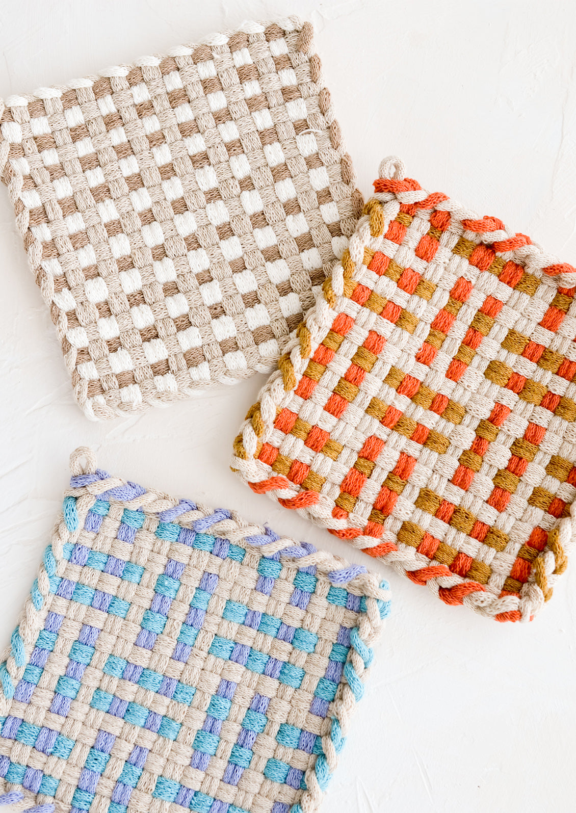 Hand knit potholders in assorted colors and patterns.