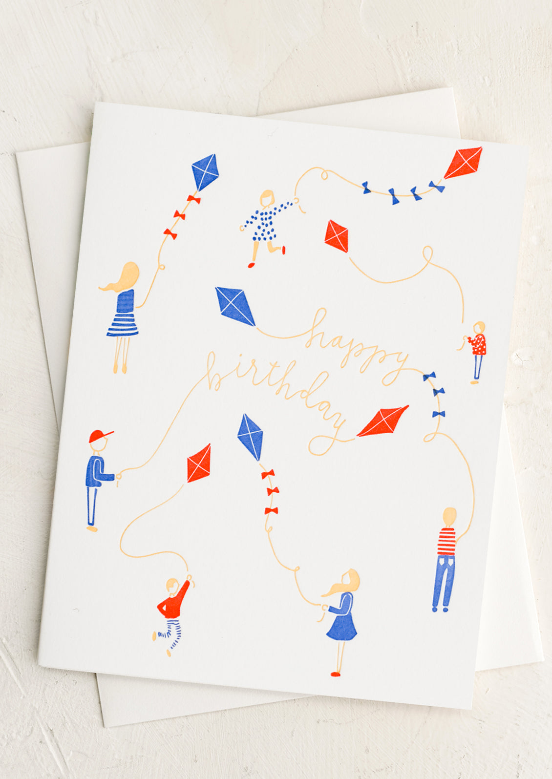 A letterpress card with children playing with kites, text reads "Happy Birthday".