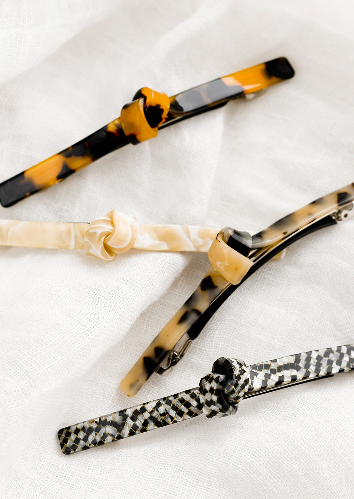 Four acetate barrettes with a knot detail in assorted colors