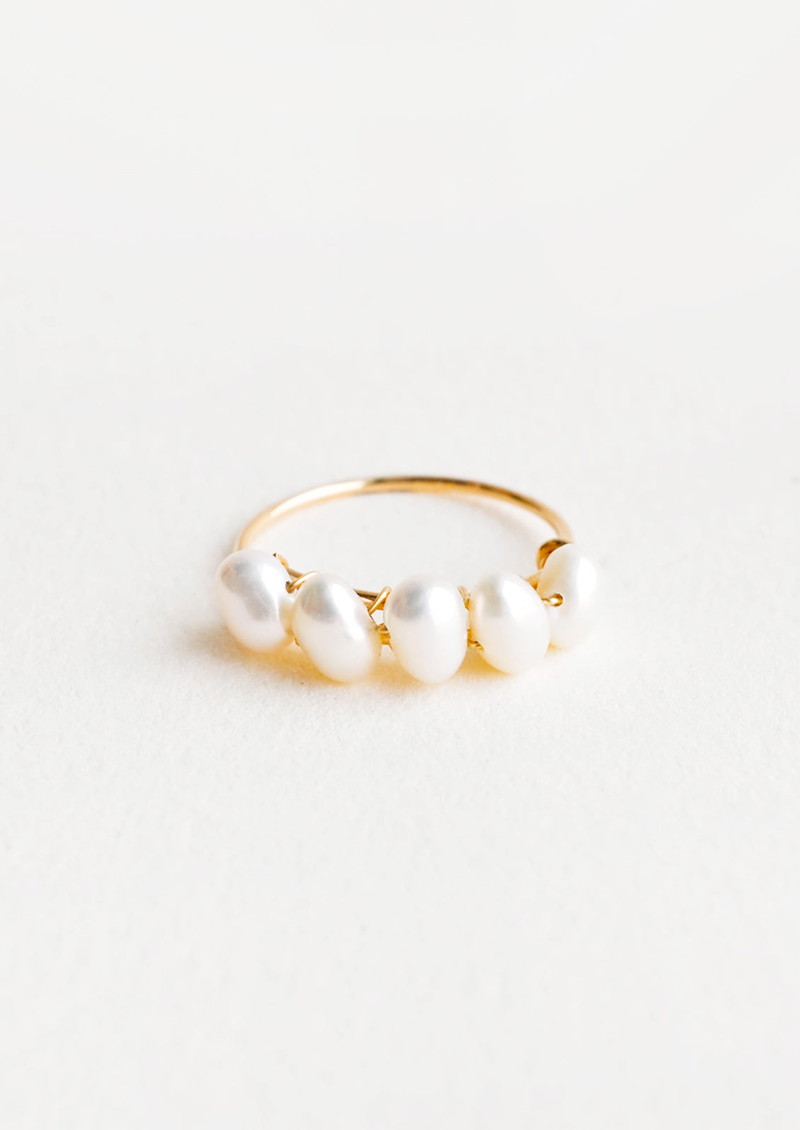 Thin gold ring with multiple pearls wrapped around front