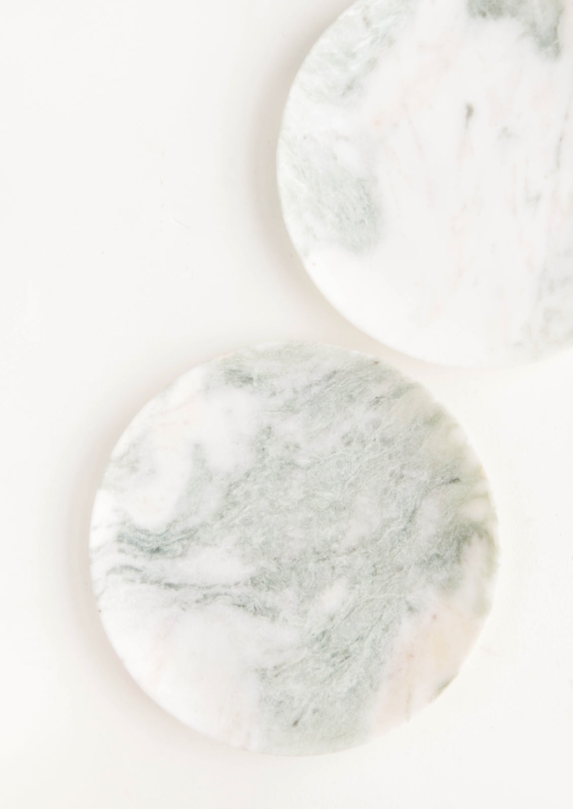 Round plates made from green and white marbled onyx