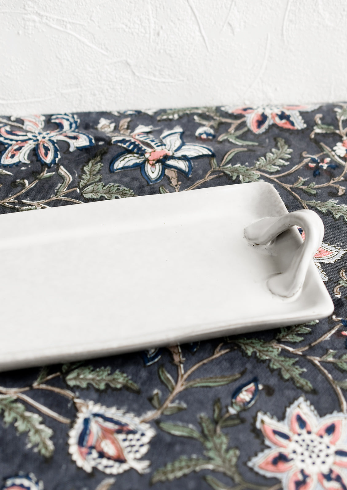 Long and skinny ceramic tray with side handle detail.