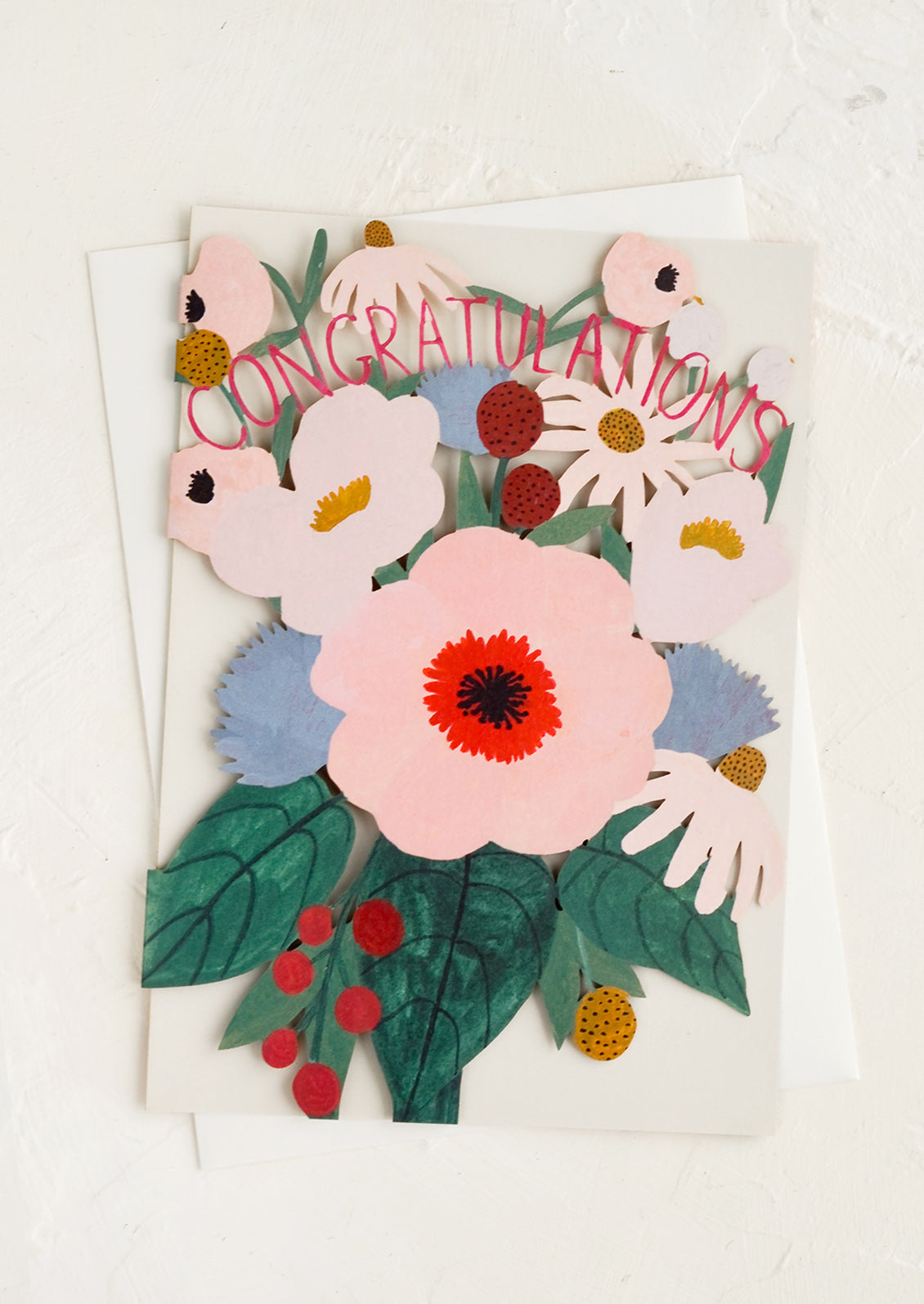 A greeting card with floral lasercut front reading "Congratulations".