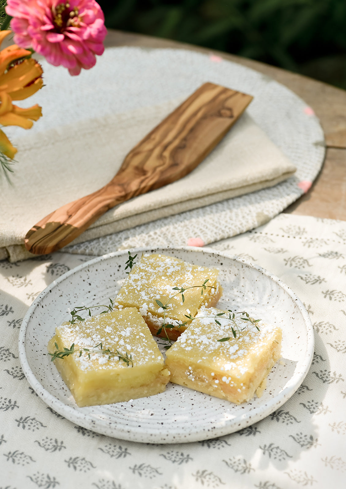 A wooden serving utensil next to lemon bars.