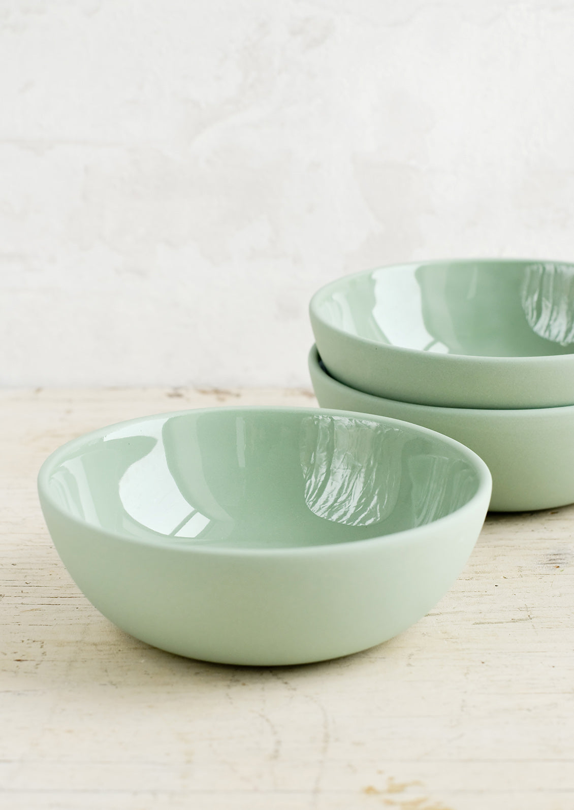Matte porcelain bowls in moss green hue with glossy interior.