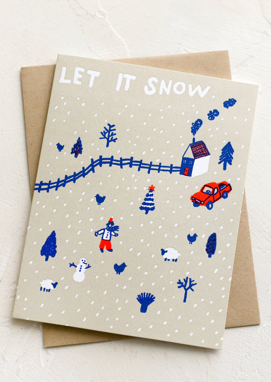 A greeting card with drawing of snowy village, text reads "Let it Snow".