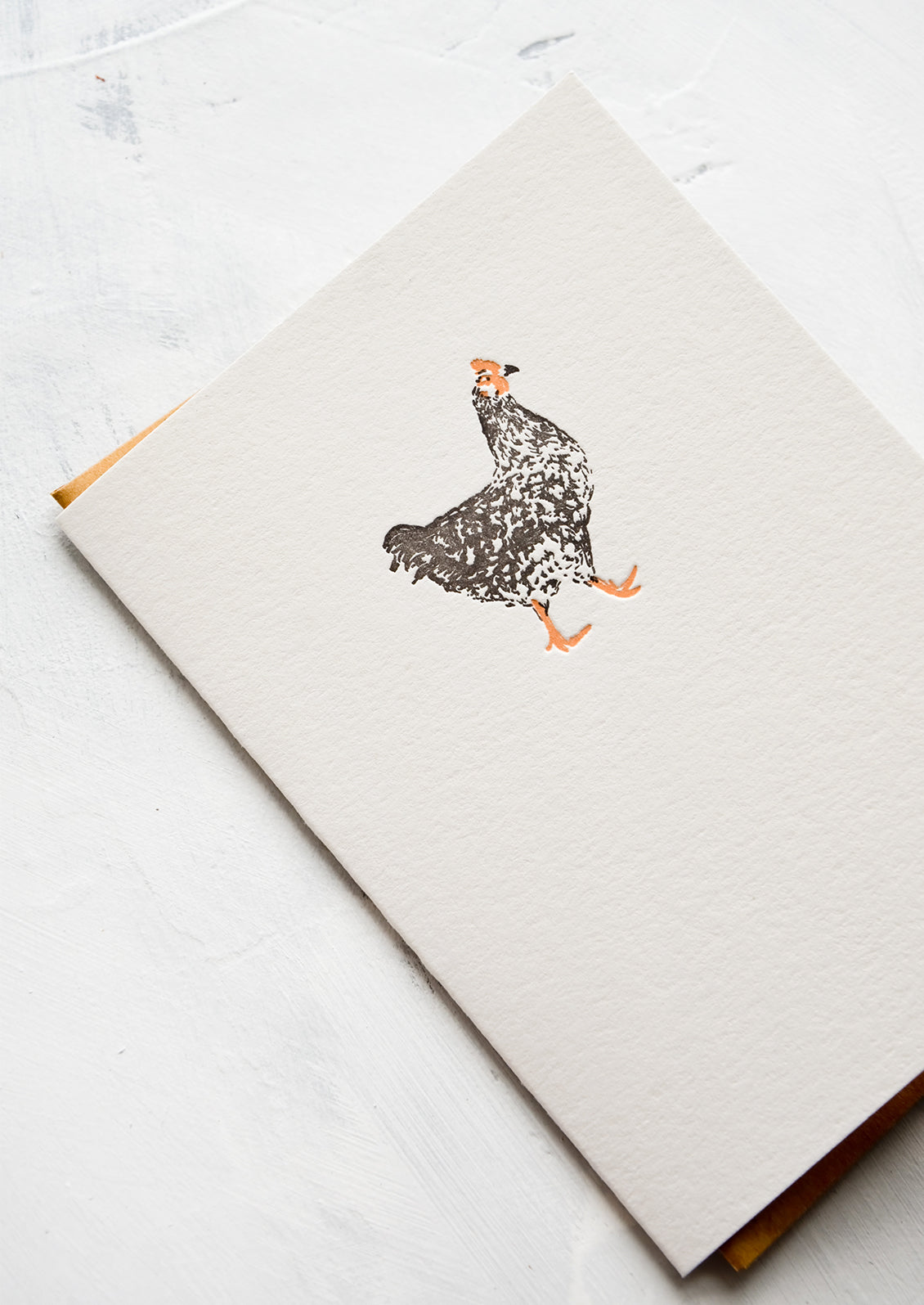 A letterpress printed greeting card with an image of a chicken