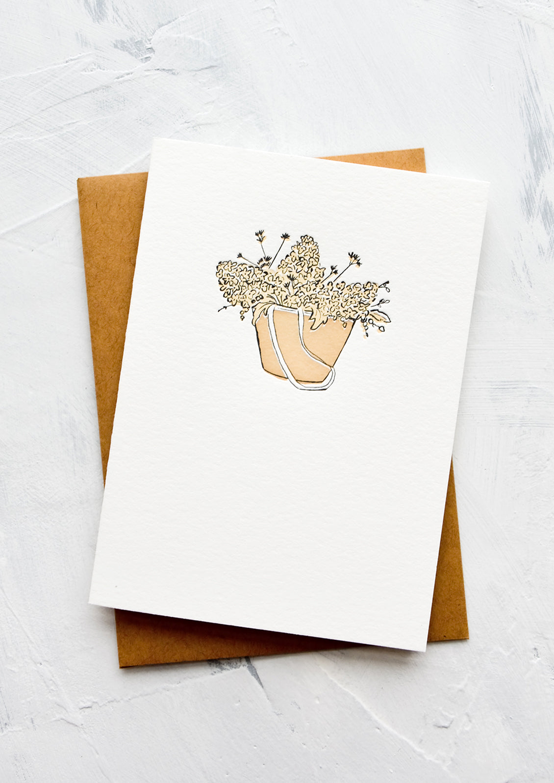 A letterpress printed greeting card with an image of hydrangeas in a tote bag