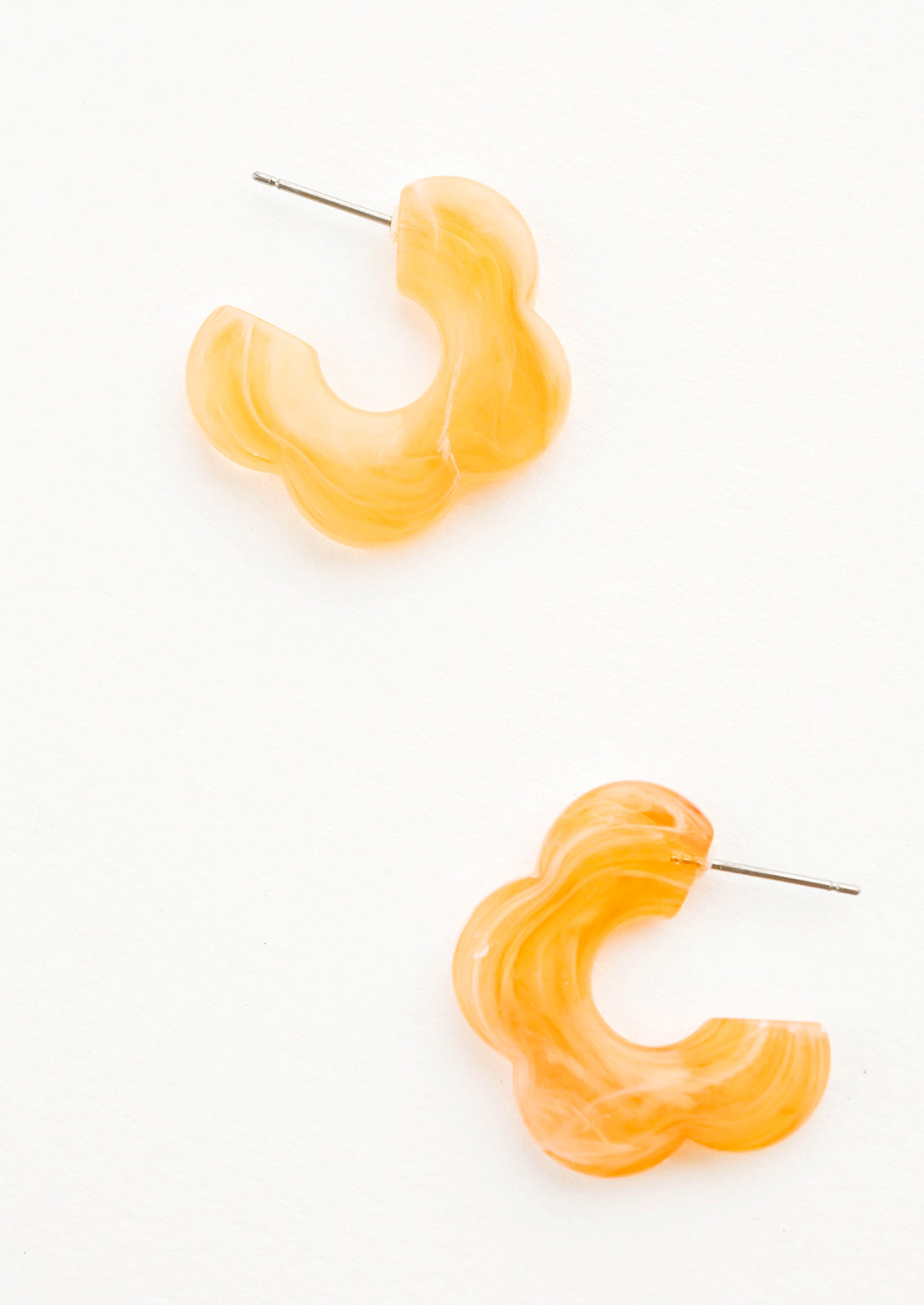 Acetate earrings in the shape of a daisy-like flower, marbled translucent apricot color