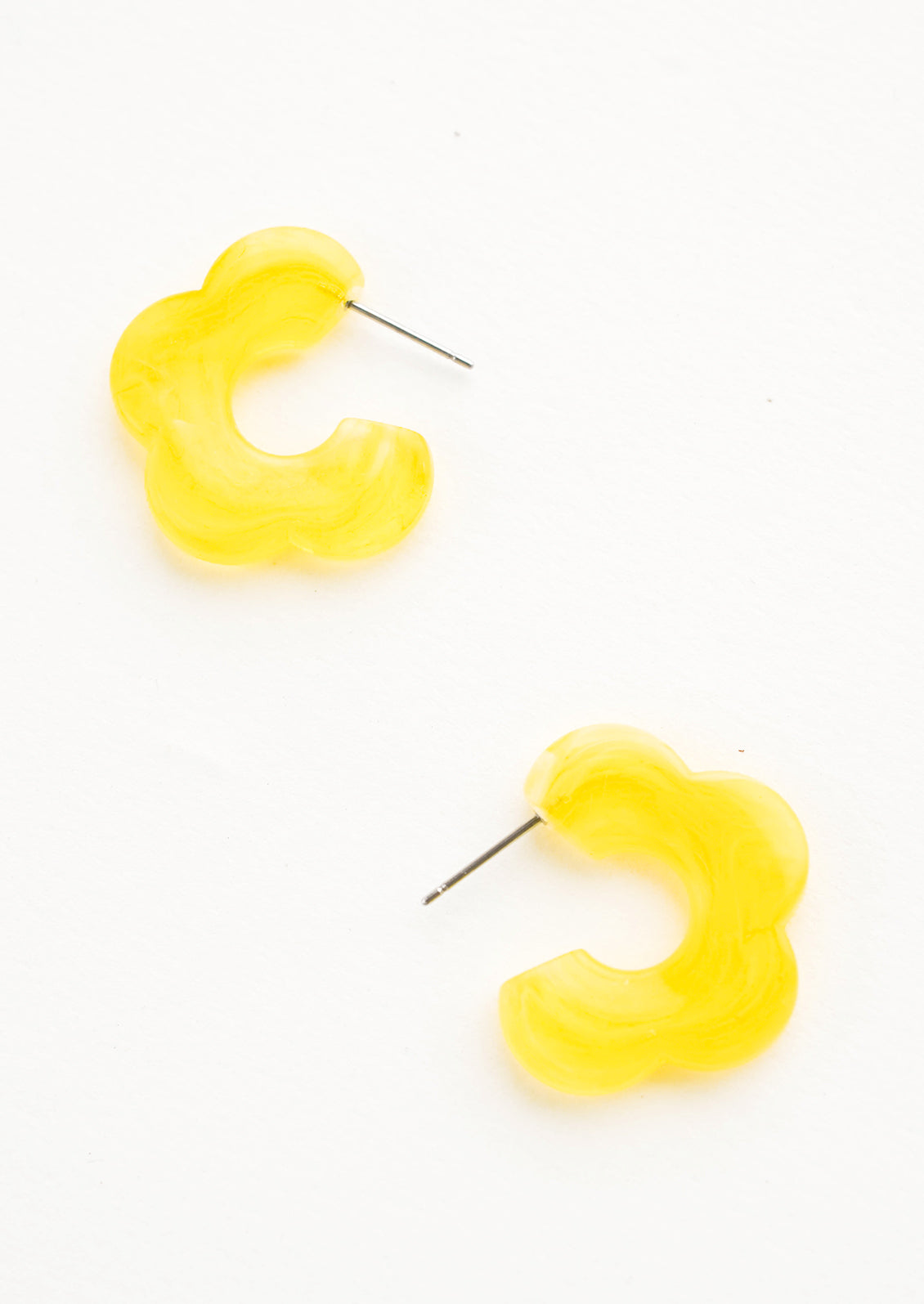 Acetate earrings in the shape of a daisy-like flower, translucent lemon yellow color