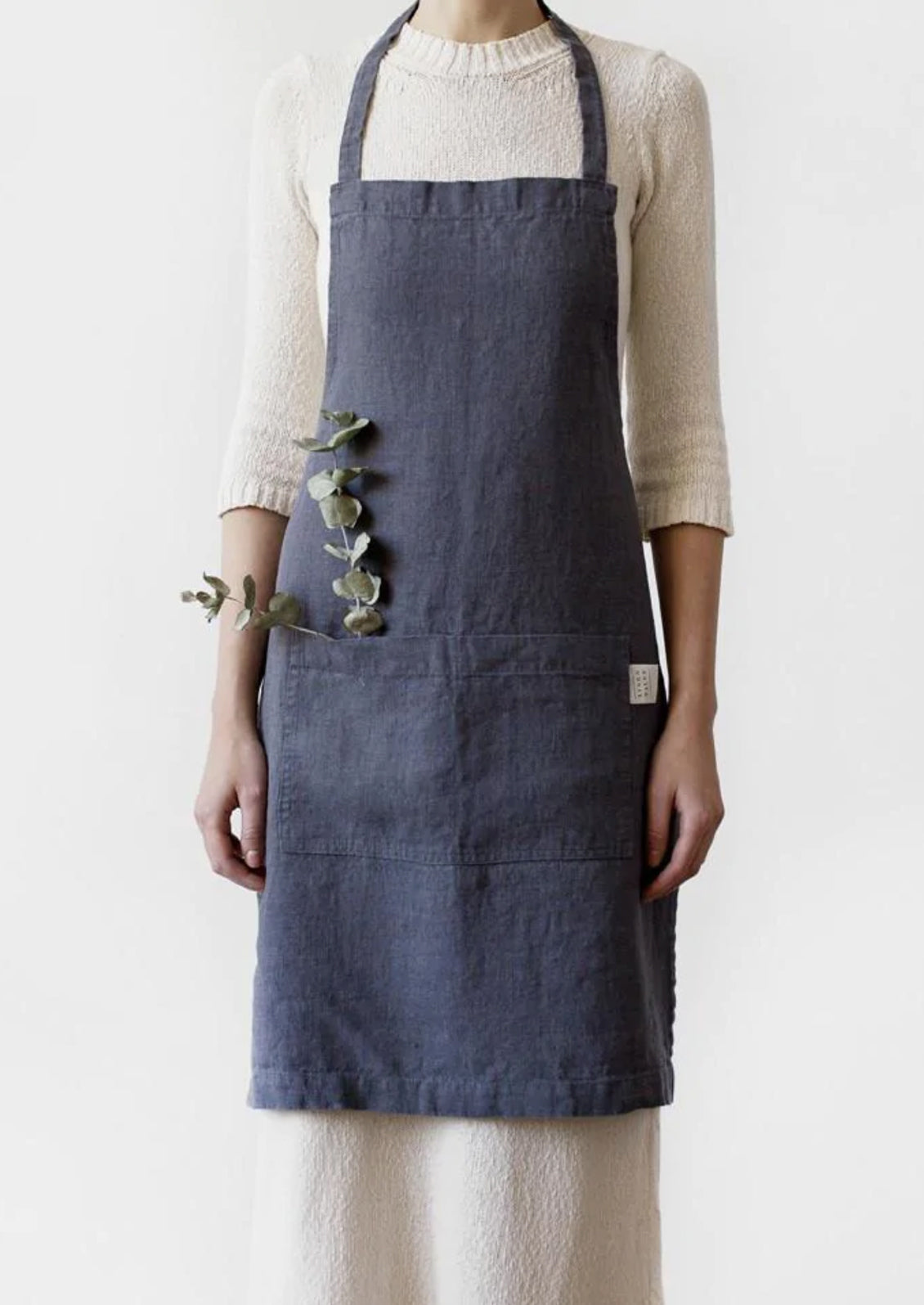 A women wearing a linen apron in dark grey color.