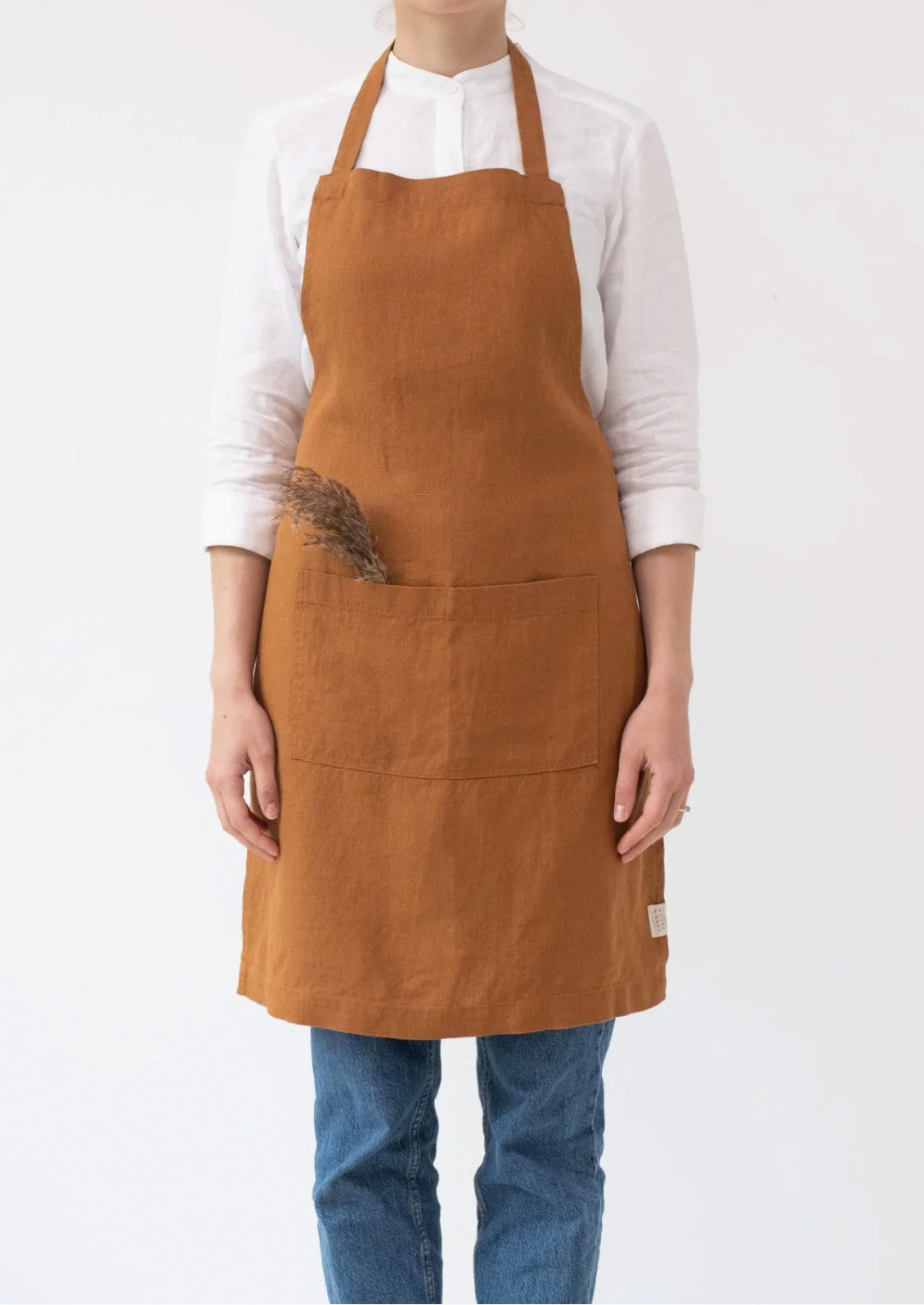 A women wearing a linen apron in bourbon color.