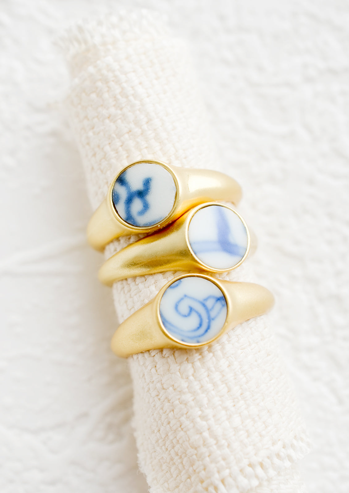 Gold signet rings with blue and white pottery signet.